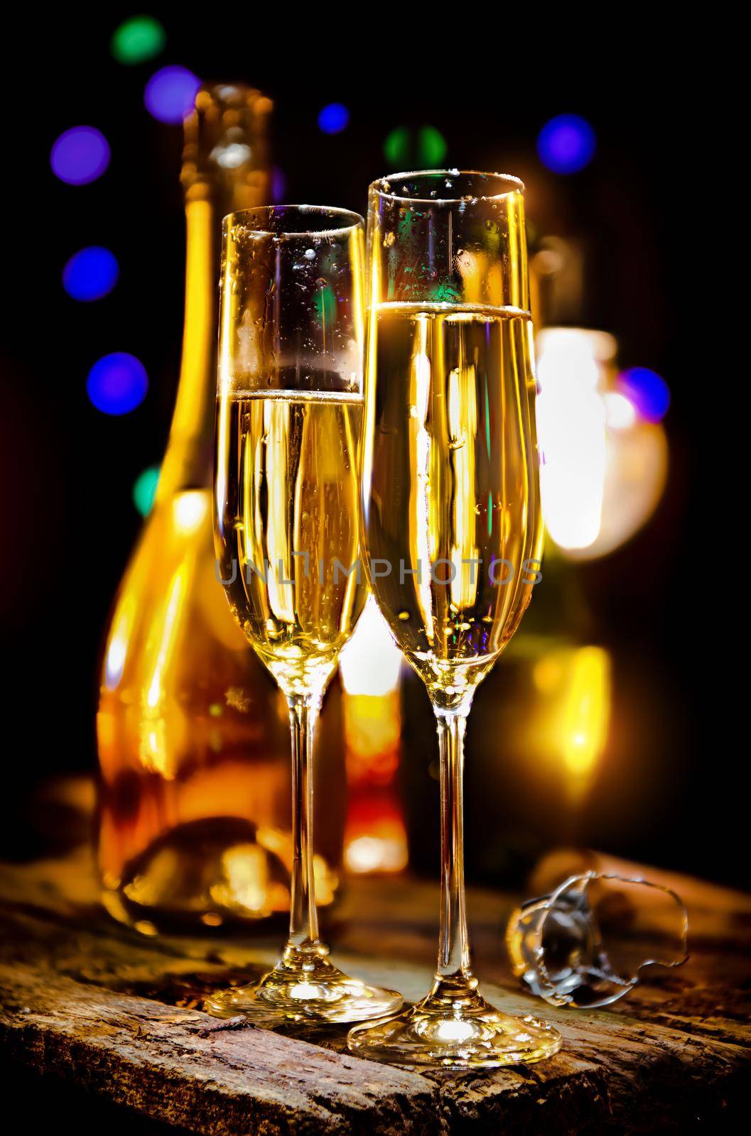 Glass and bottle of champagne on a black background