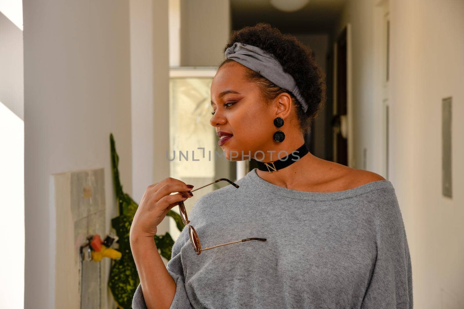 A pretty young African American confident woman in the stairwell of an old apartment building.