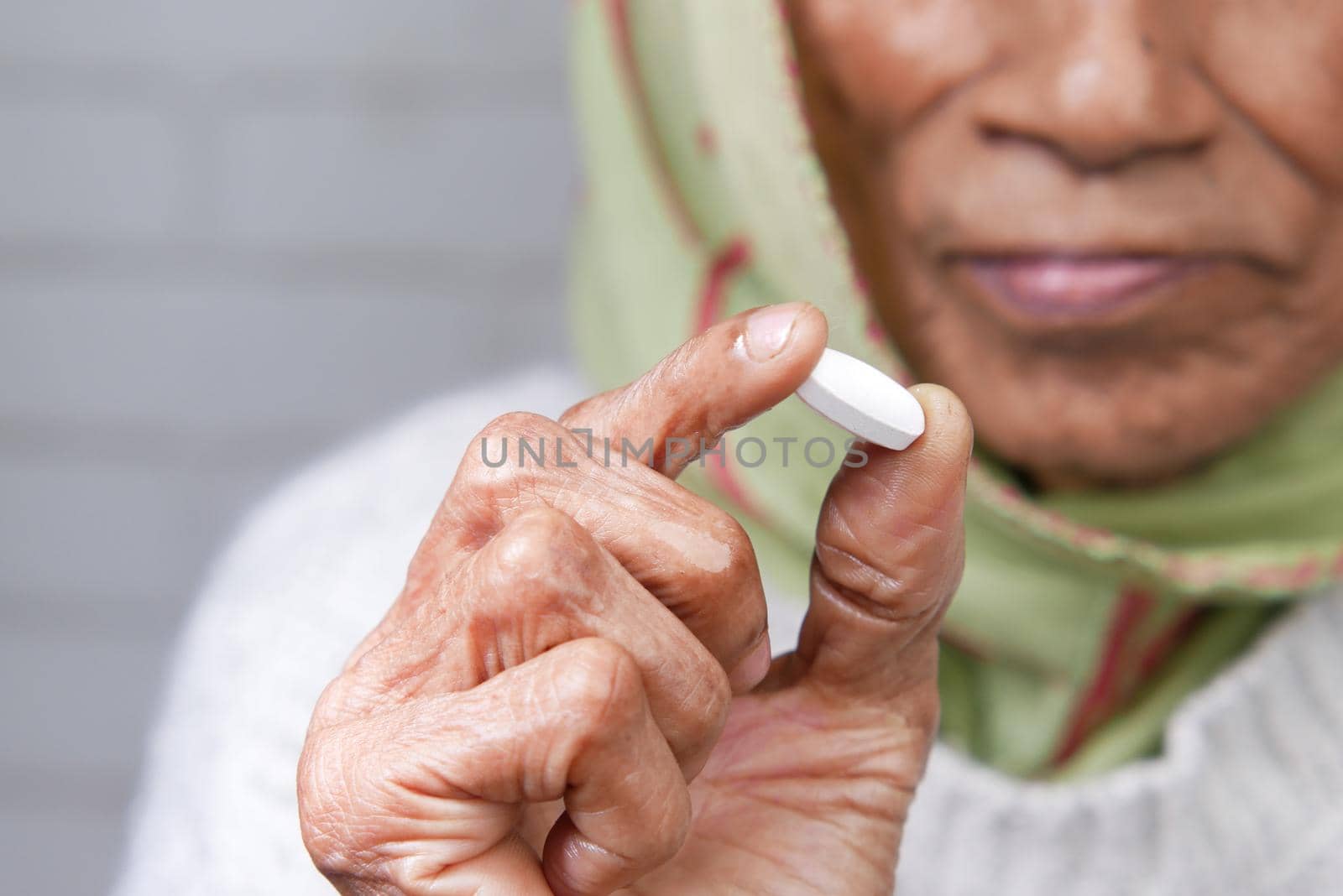 Close up of senior women hand holding pills with copy space .