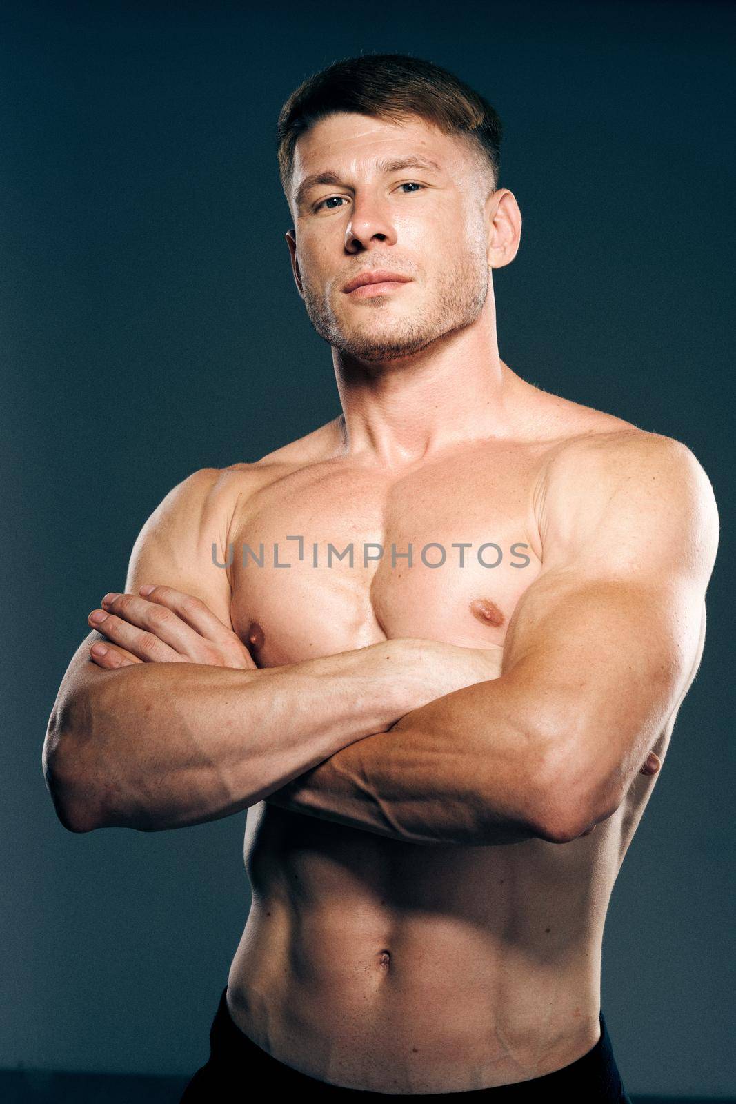 athletic male topless workout muscle bodybuilder dark background. High quality photo