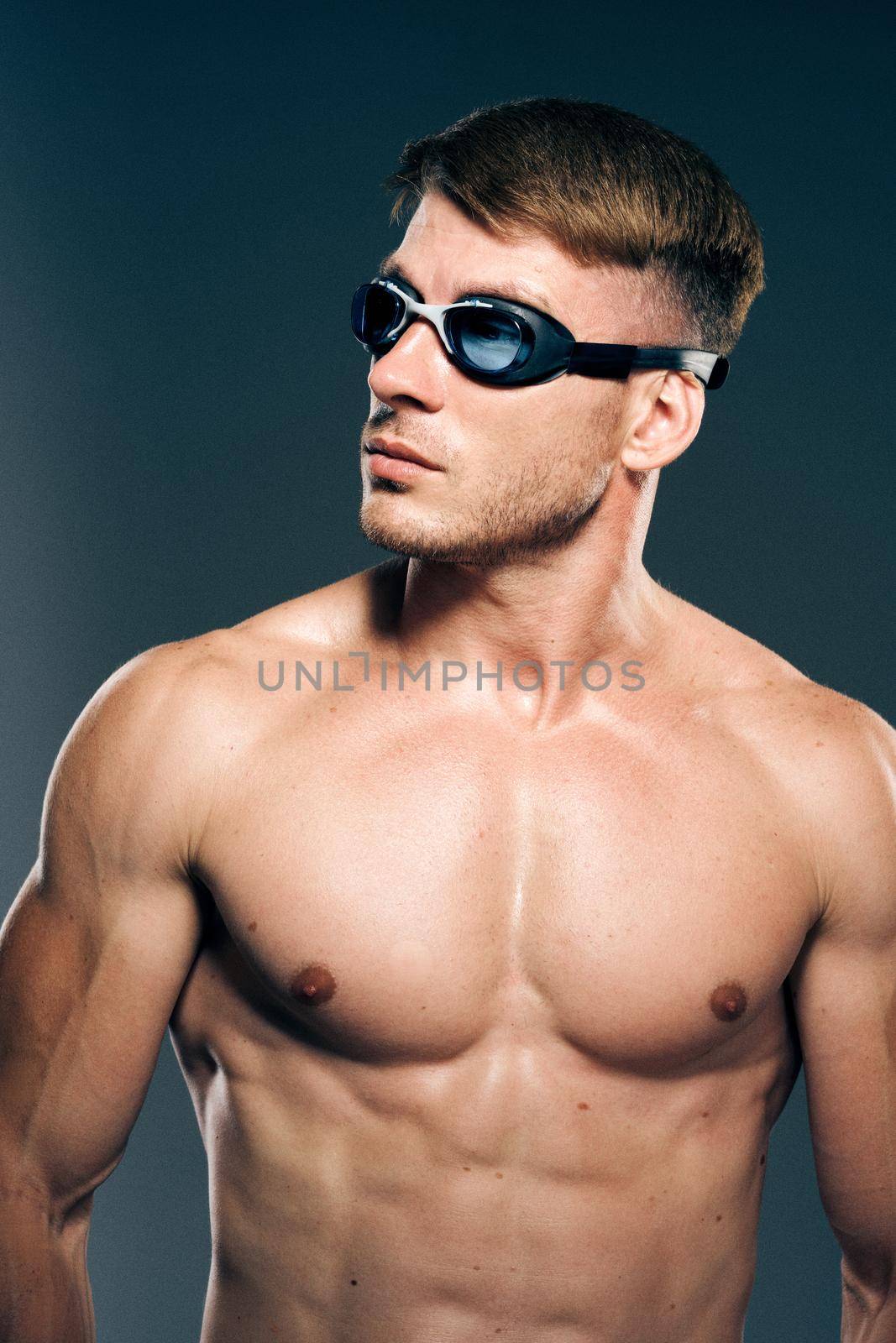 sports man with naked torso swimmer professional dark background. High quality photo