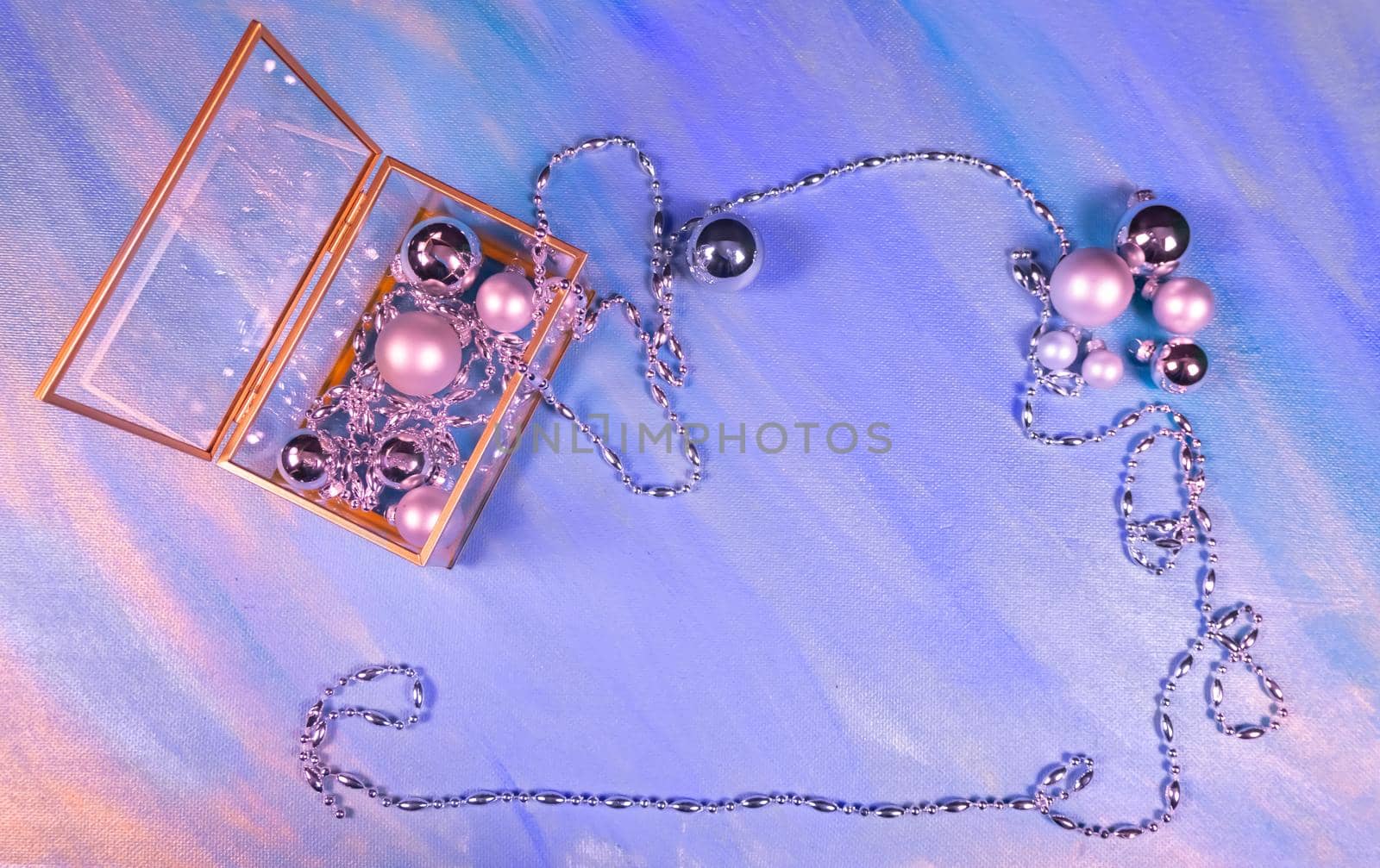 silver Christmas toys and garland on violet background, top view, flat lay, copy space by kajasja