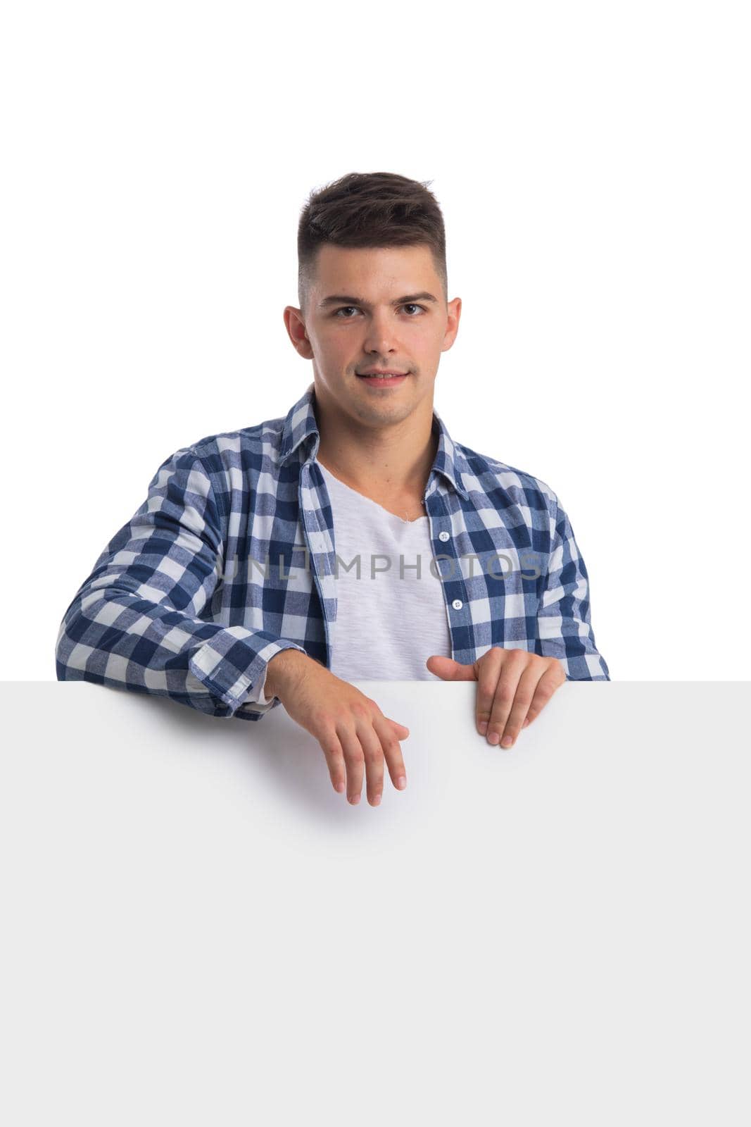 Young happy casual man holsing blank banner isolated on white backgrounf