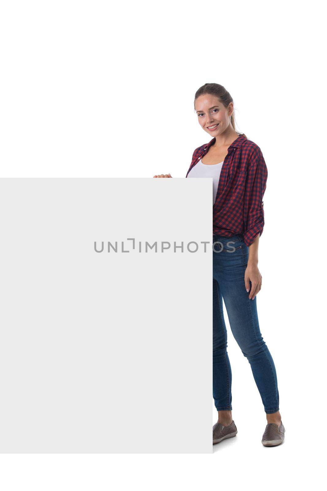 Young beautiful woman smiling showing blank white placard billboard sign. Casual caucasian female model with friendly smile. Isolated on white background