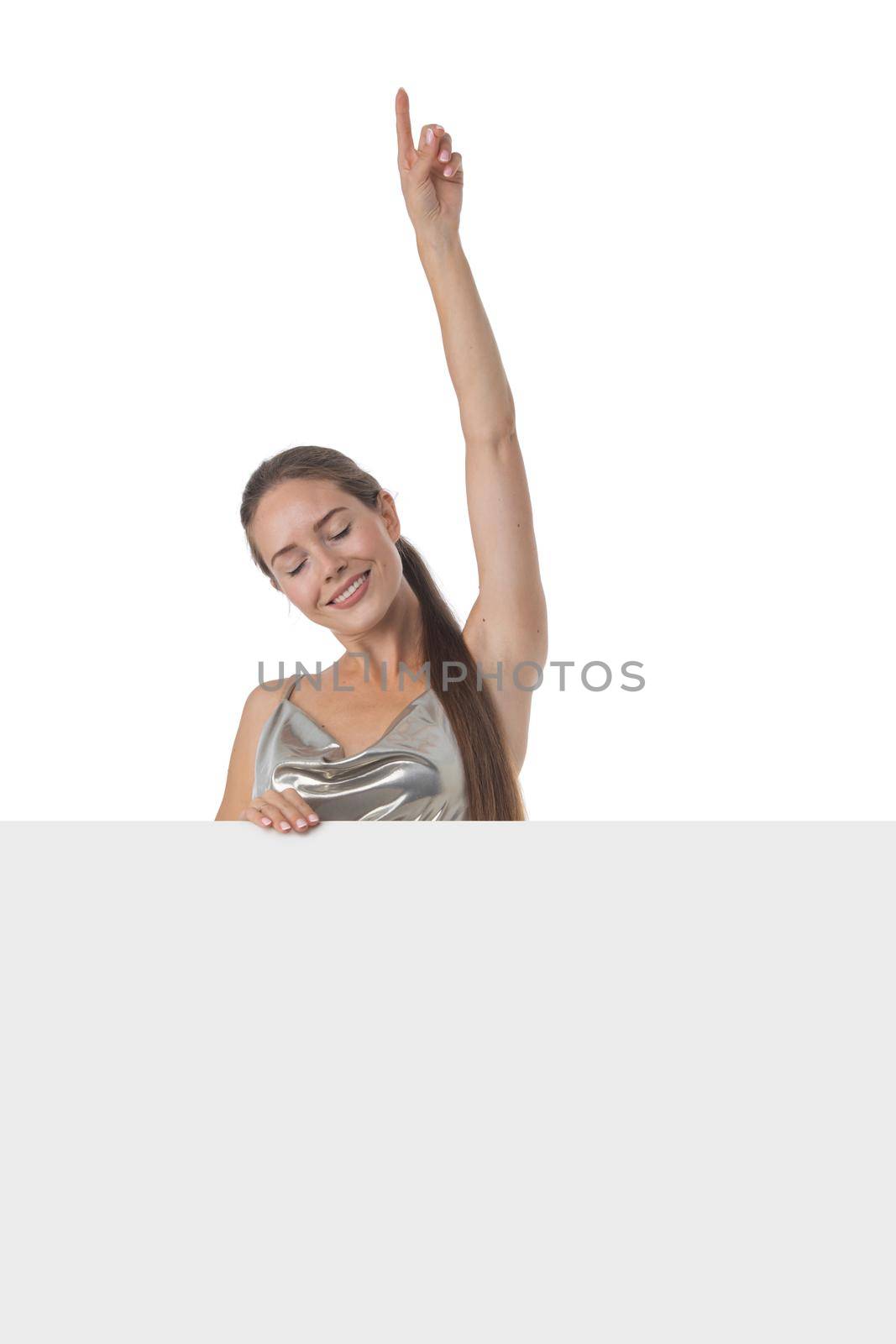 Young party girl in silver dress displaying blank banner isolated over white background