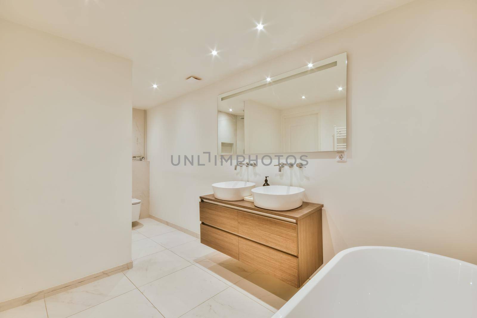 Luxurious bathroom with a beautiful hanging wooden chest of drawers with a sink
