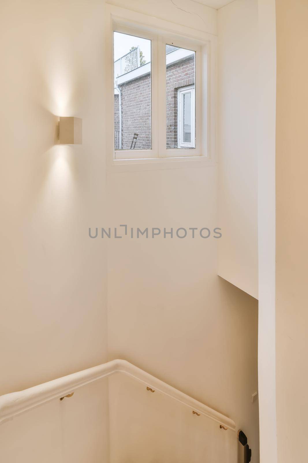 Convenient white stair handrails and window on the wall