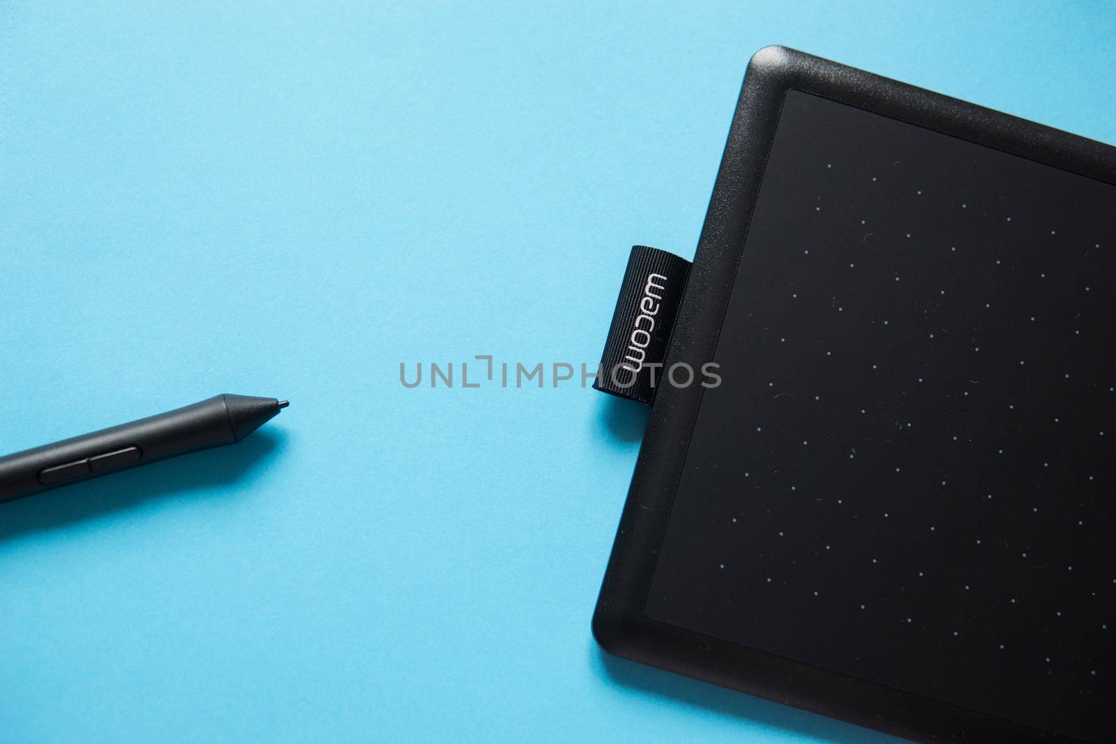 Tver, Russia - February 3, 2020 Top view of Wacom graphic tablet on blue background. Space for text. Selective focus.
