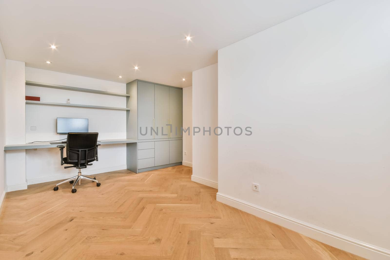 Work area in a bright room with a computer and a wardrobe