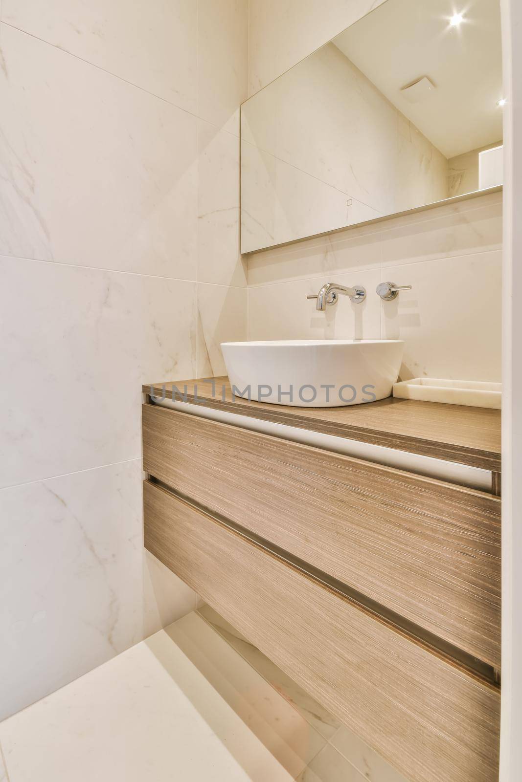 Luxurious bathroom with a hanging chest of drawers with a sink by casamedia