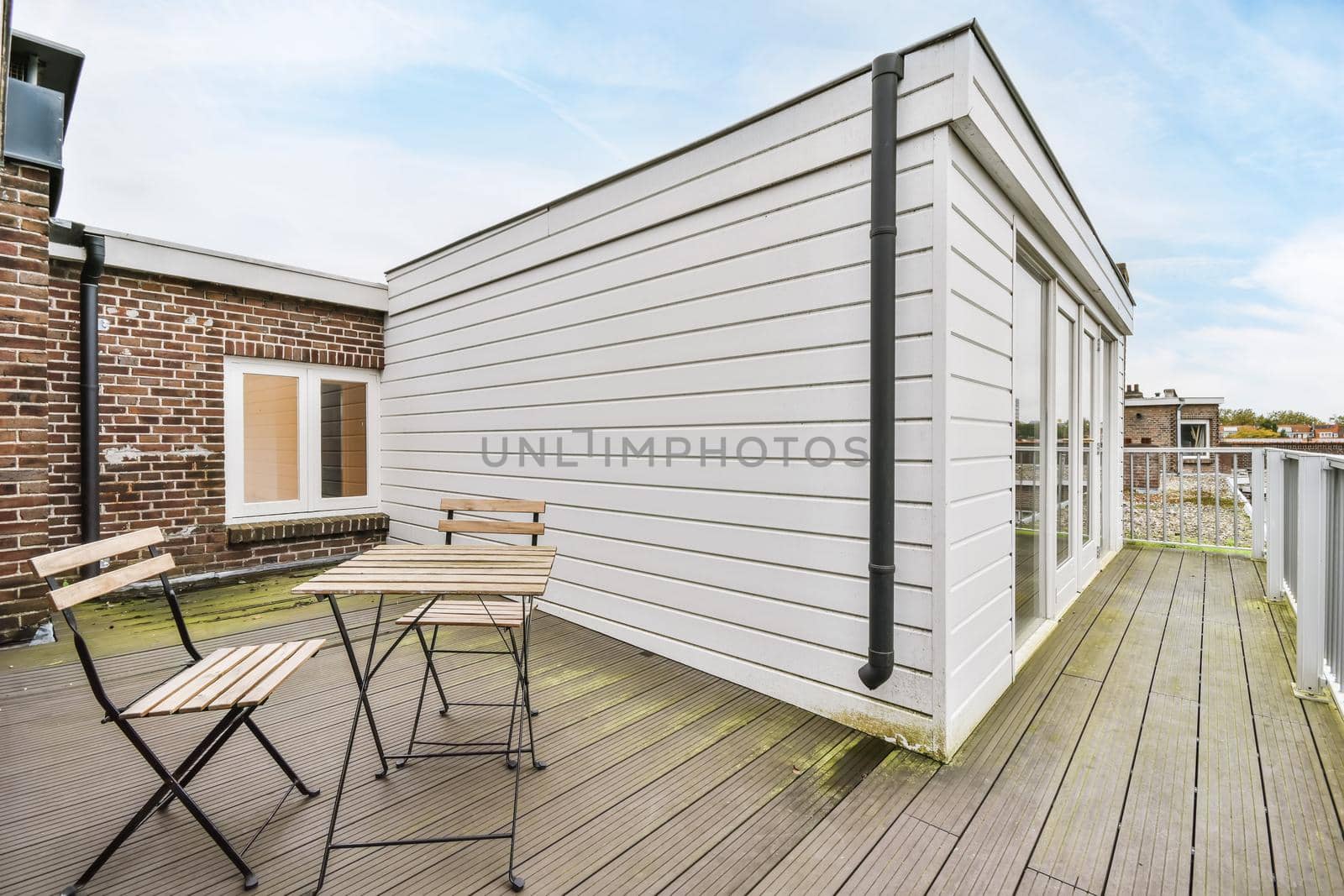 Large balcony with wooden table and chair