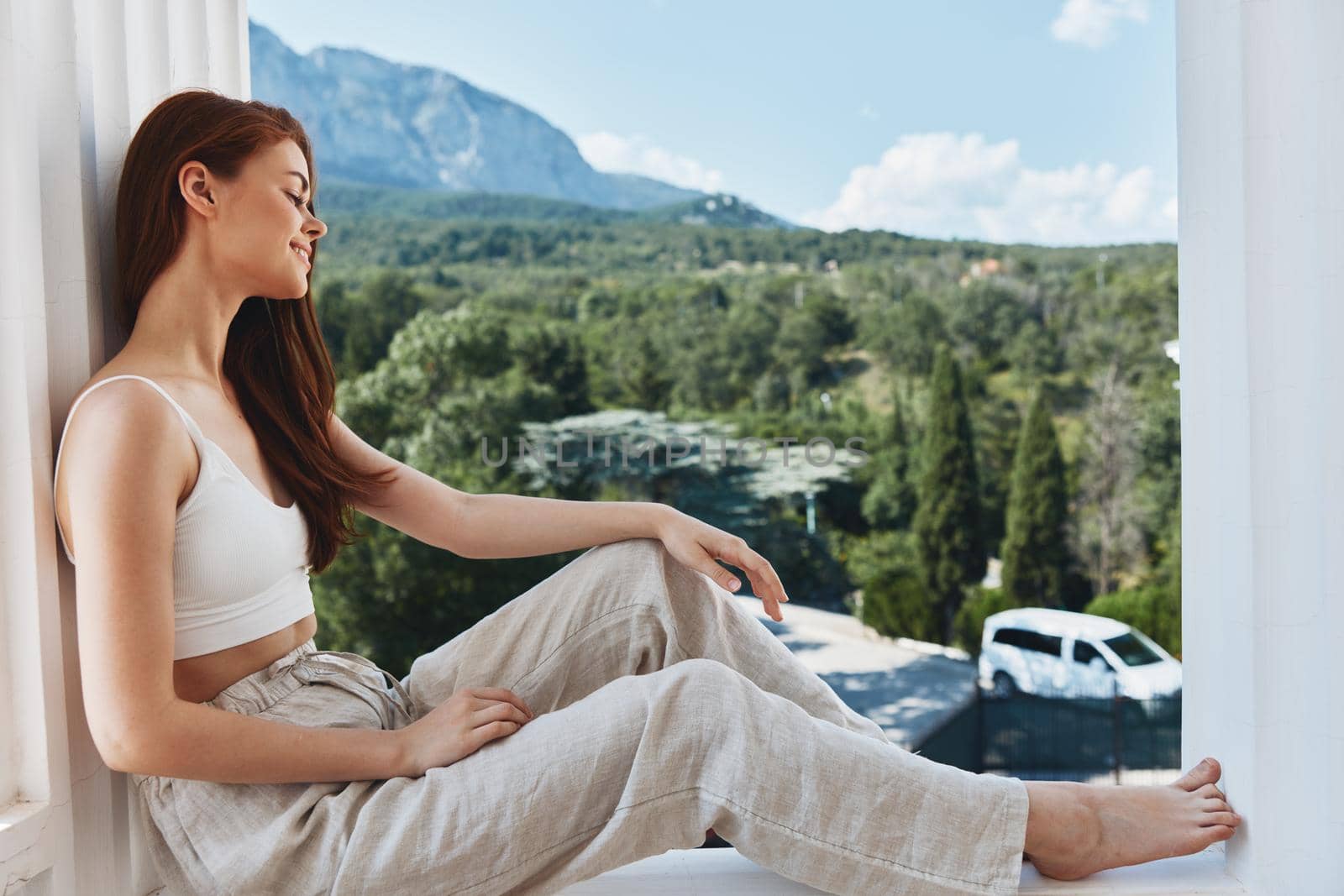 Attractive young woman sitting on the balcony beautiful mountain view summer Mountain View. High quality photo