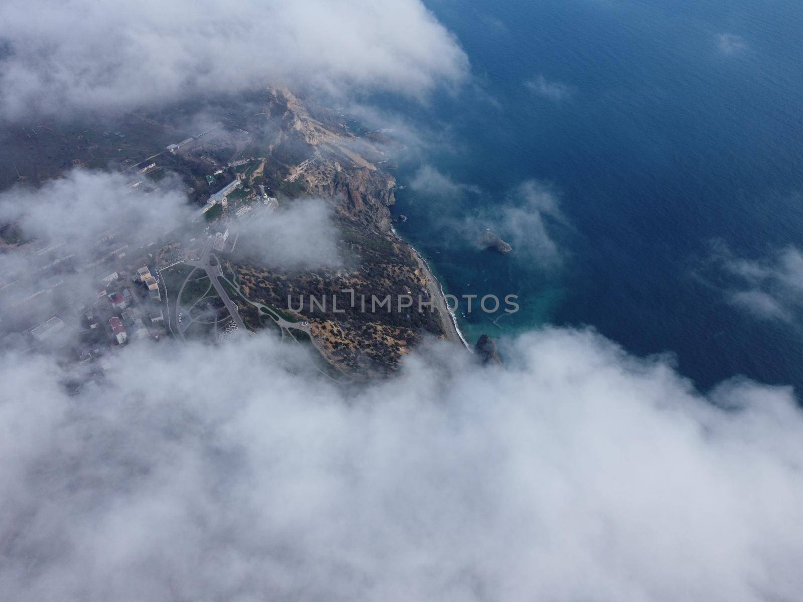 Camera is raising above from the thick fog above the beautiful ocean of clouds at sunrise. Sun is rising above the endless sea of clouds until the horizon. Amazing nature landscape, 4K drone in sky