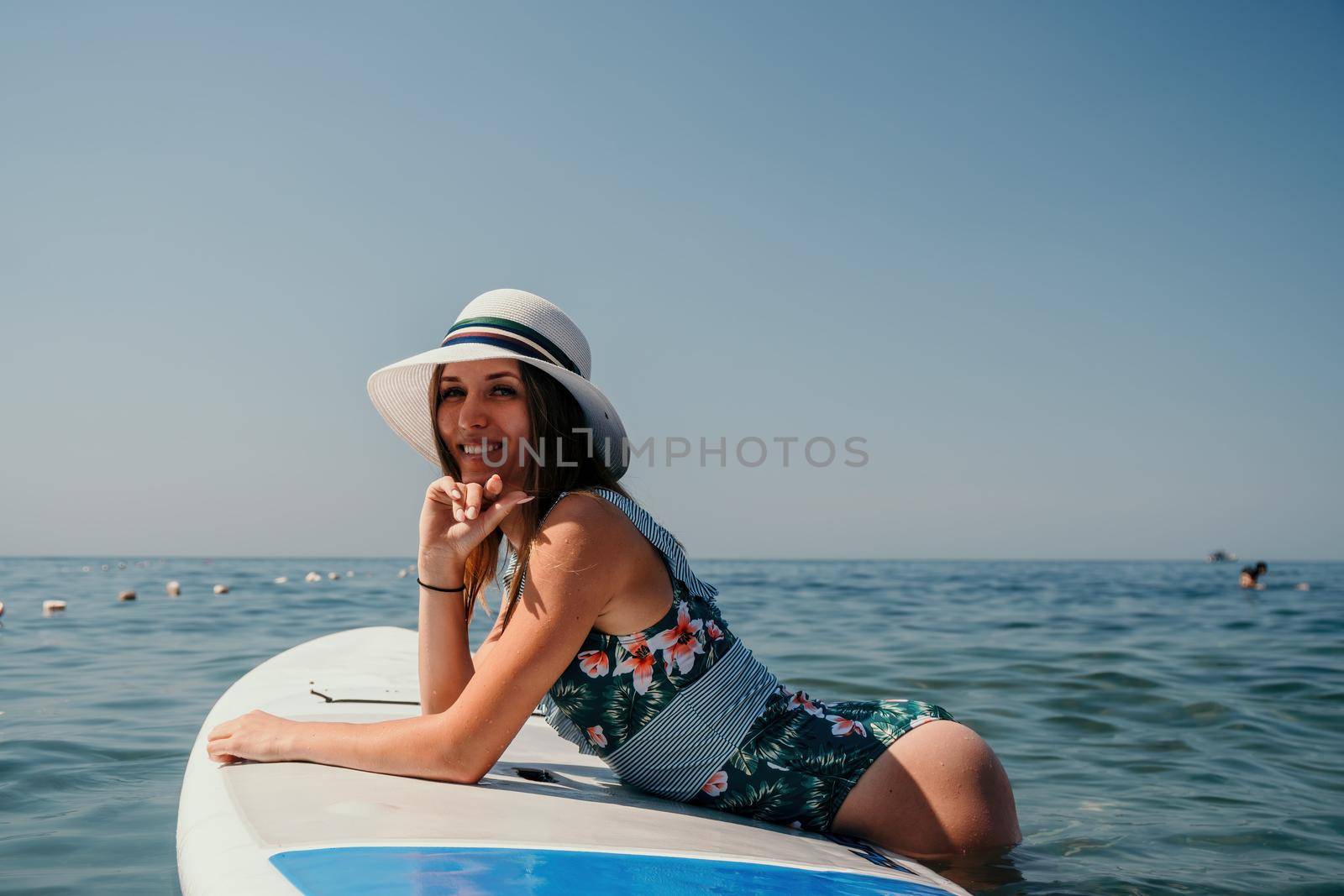 SUP Stand up paddle board. Young woman sailing on beautiful calm sea with crystal clear water. The concept of an summer holidays vacation travel, relax, active and healthy life in harmony with nature. by panophotograph