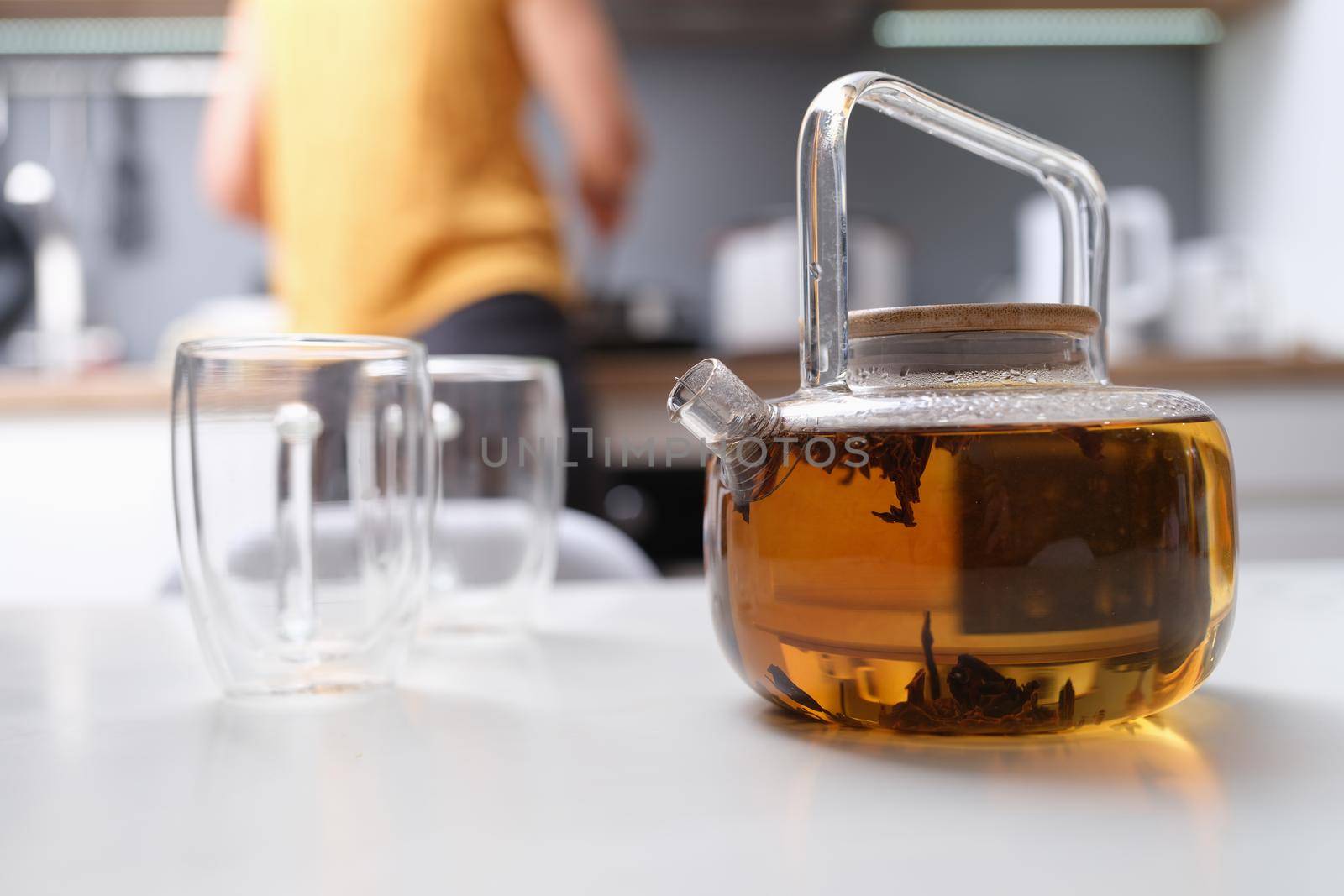 A woman made tea in a glass teapot, close-up by kuprevich