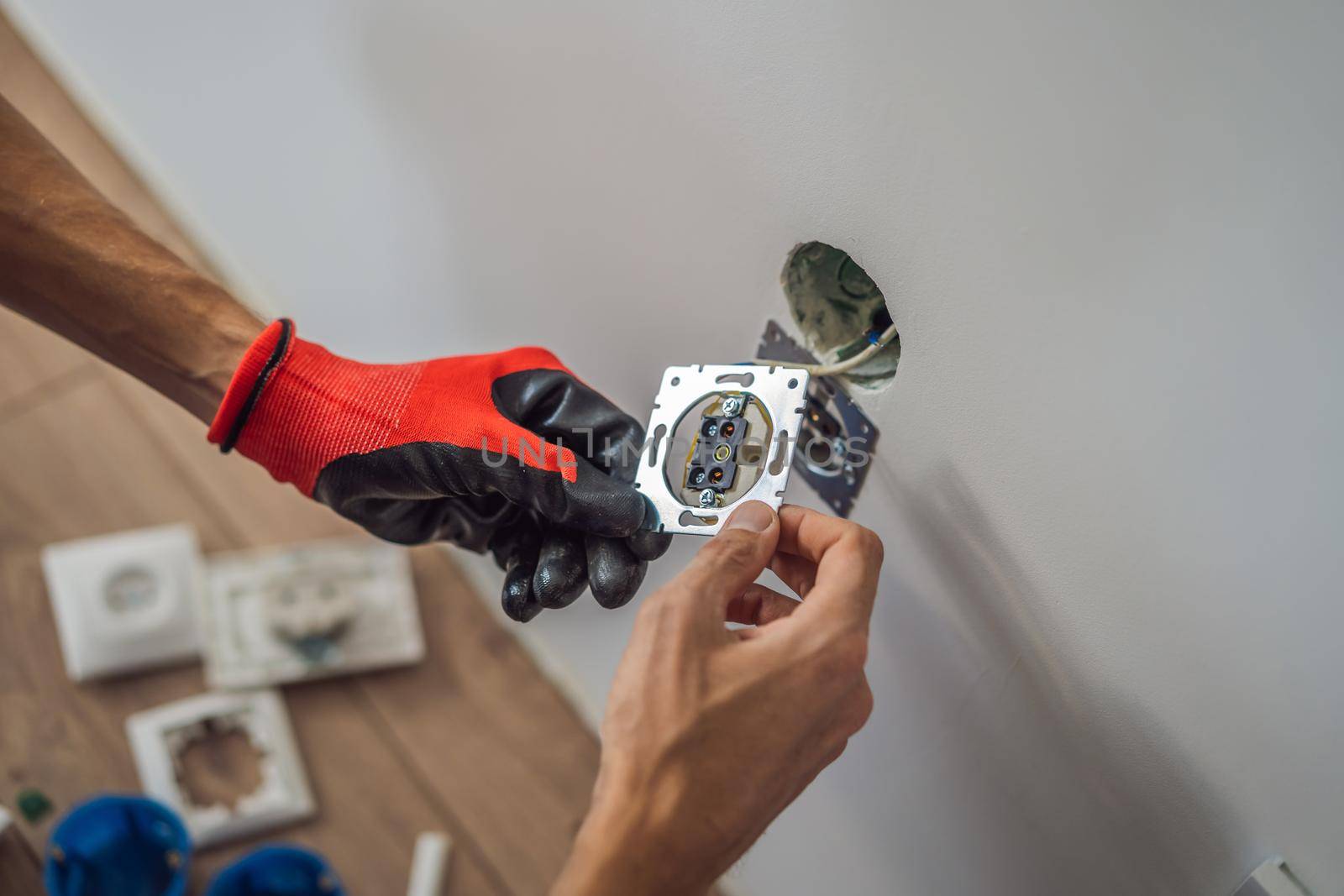 Master electrician installs a socket in the house.