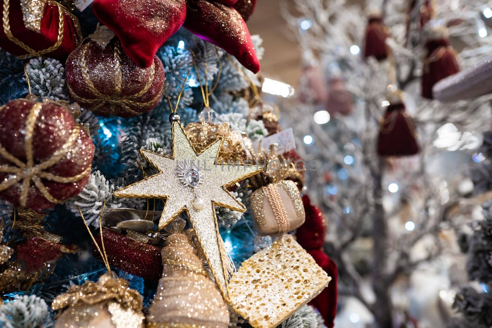 Close up of different object toy gifts hanging on a decorated Christmas tree.