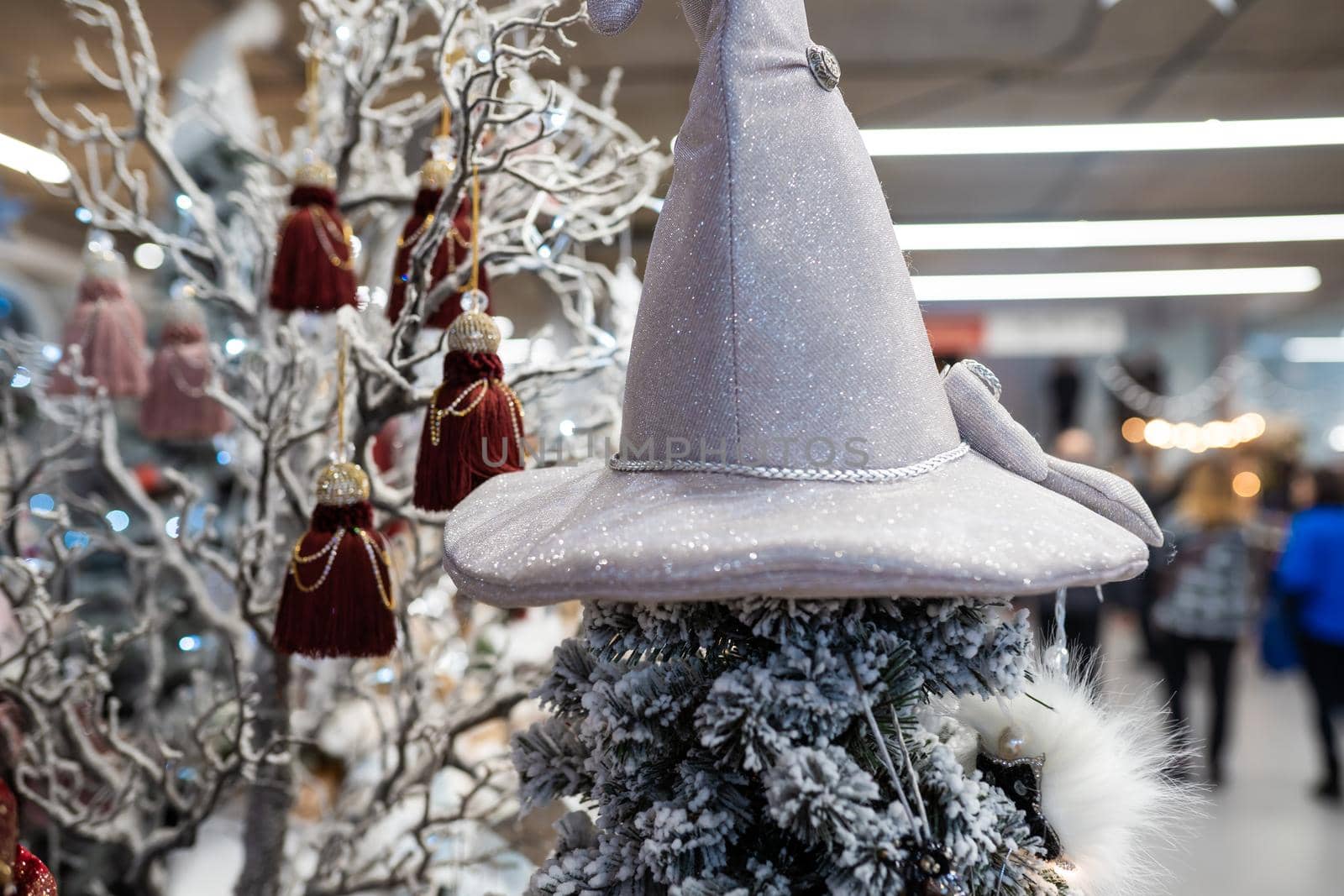 Close up of different object toy gifts hanging from a decorated Christmas tree.