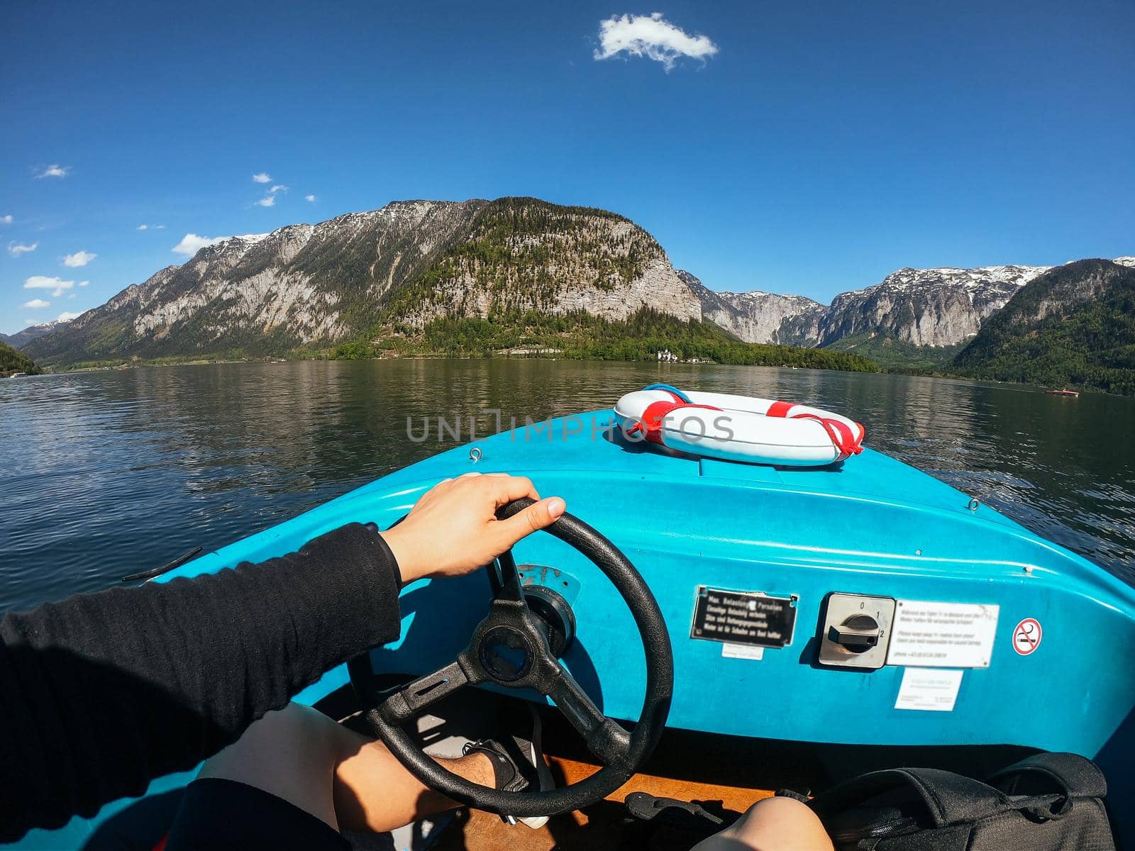Guy controls a motorboat on a mountain lake