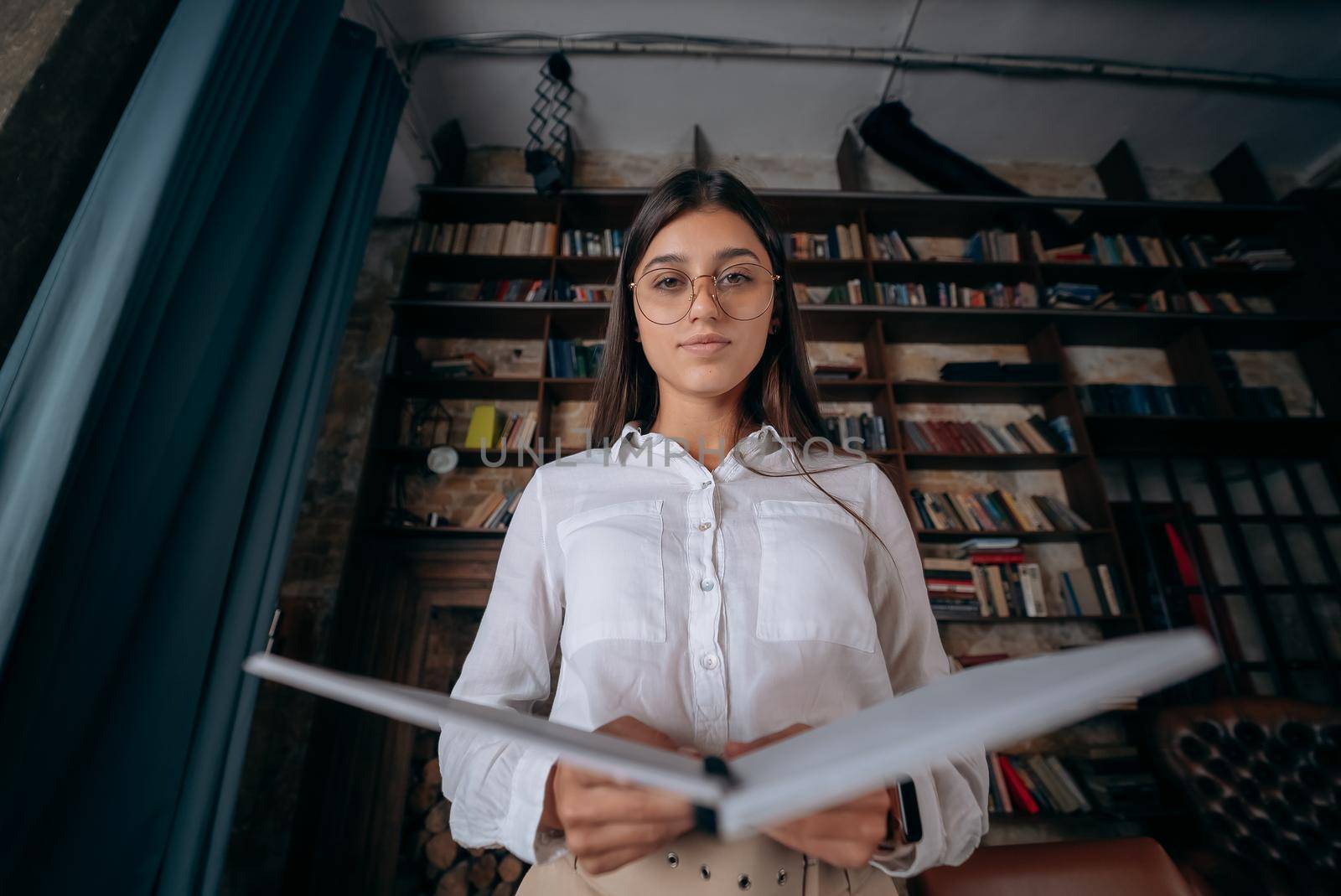 Young woman holding an open book in hands