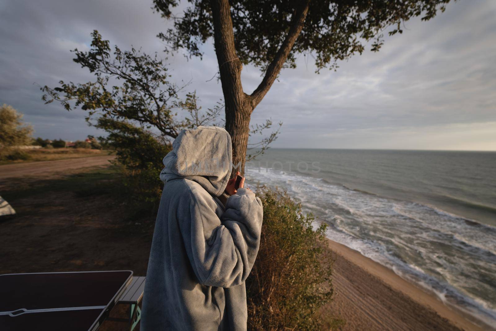 Woman takes a photo on a smartphone of the seascape