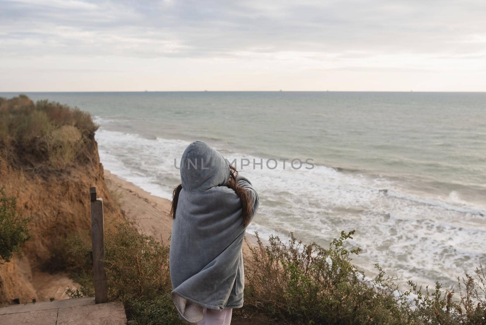 Woman on cold autumn seashore posing at camera