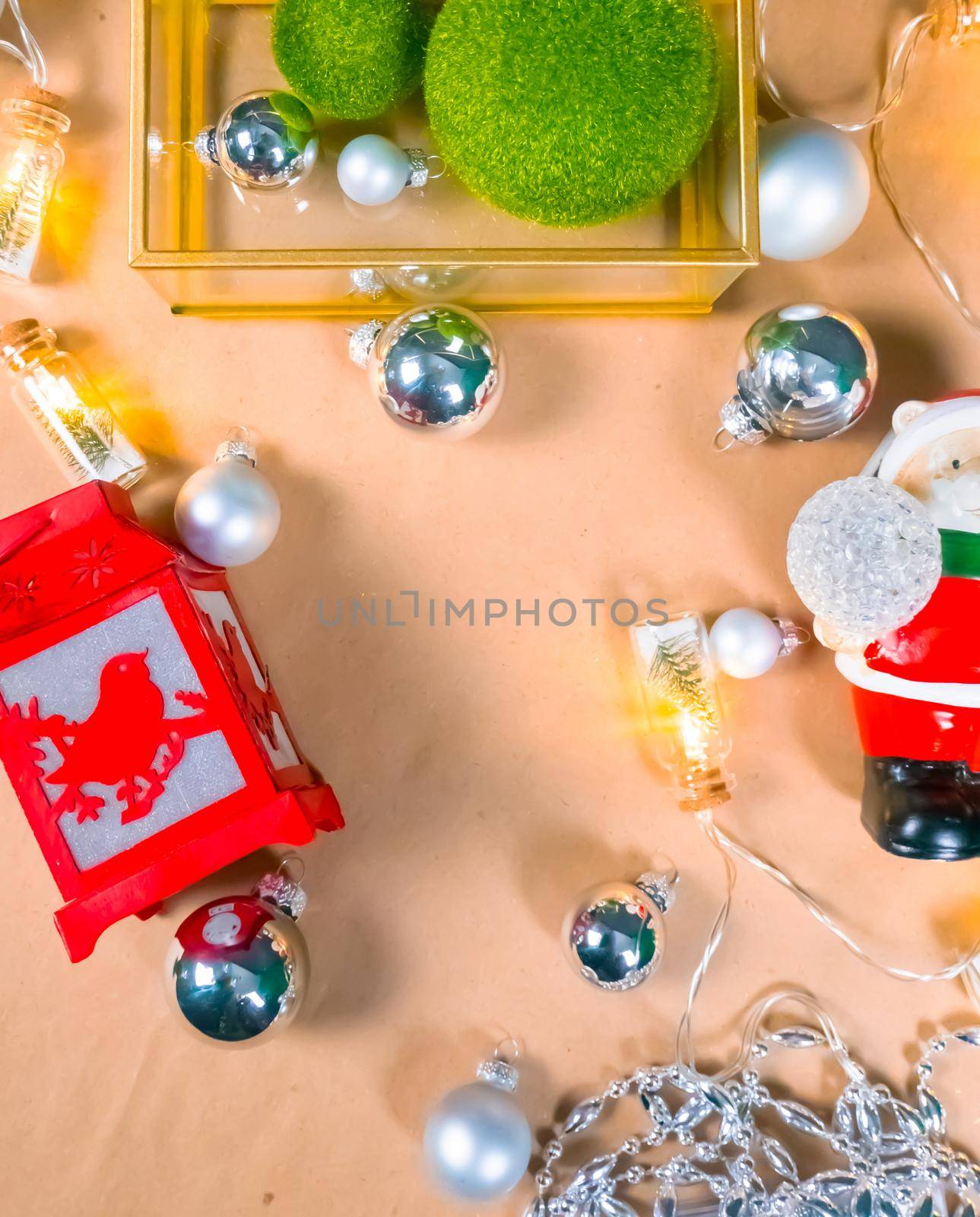 Christmas and New Year's background made of environmentally friendly materials: kraft paper, green grass balls, silver balls and beads, a magic garland with Christmas trees, a Christmas flashlight and a Santa Claus wig. High quality photo