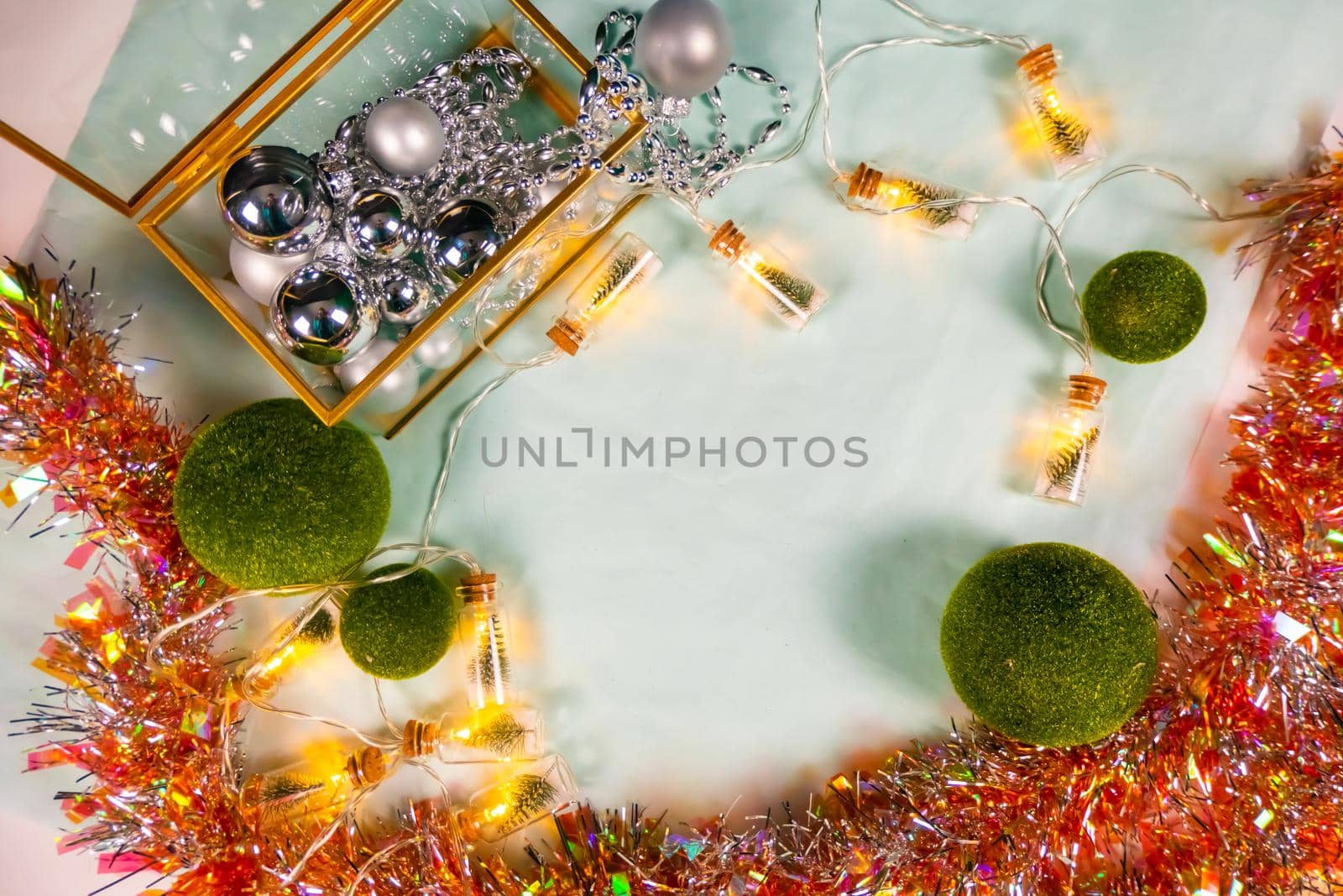 magic garland - Toy Christmas trees in glass jars and green grass balls, on a blue background. a glass casket with silver ornaments. magical holiday mood. flat lay High quality photo