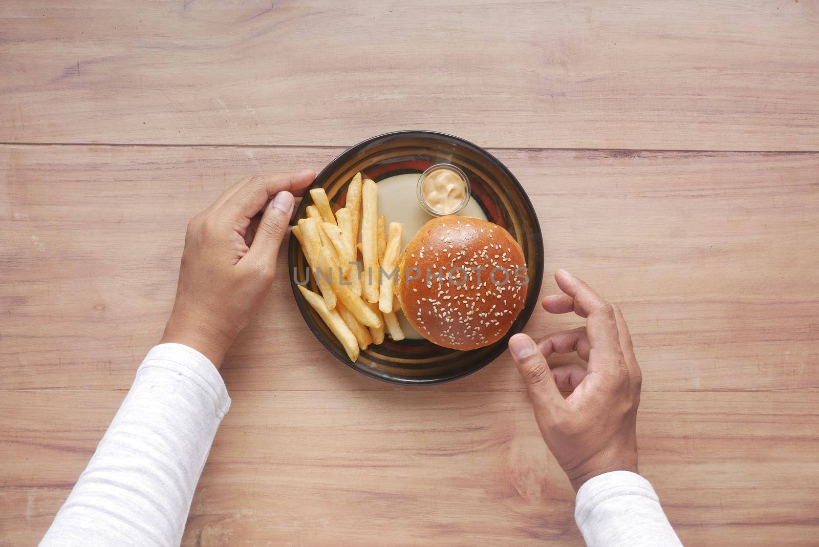 hand holding beef burger on table close up .