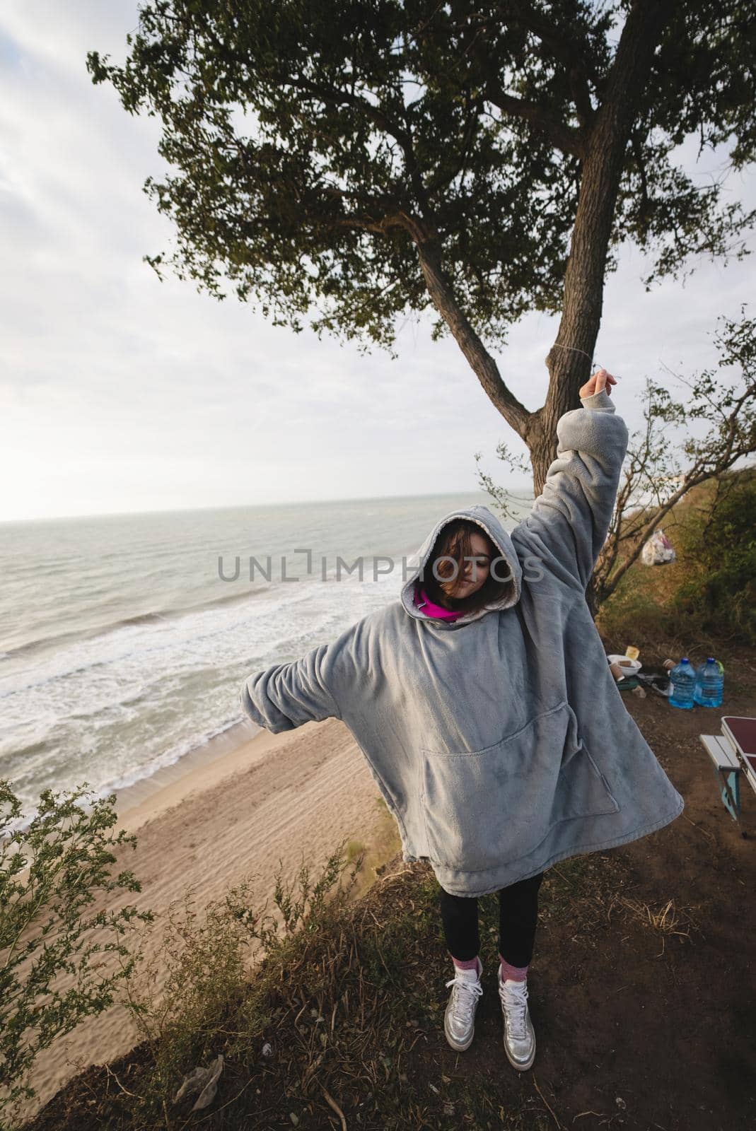 Woman on cold autumn seashore posing at camera