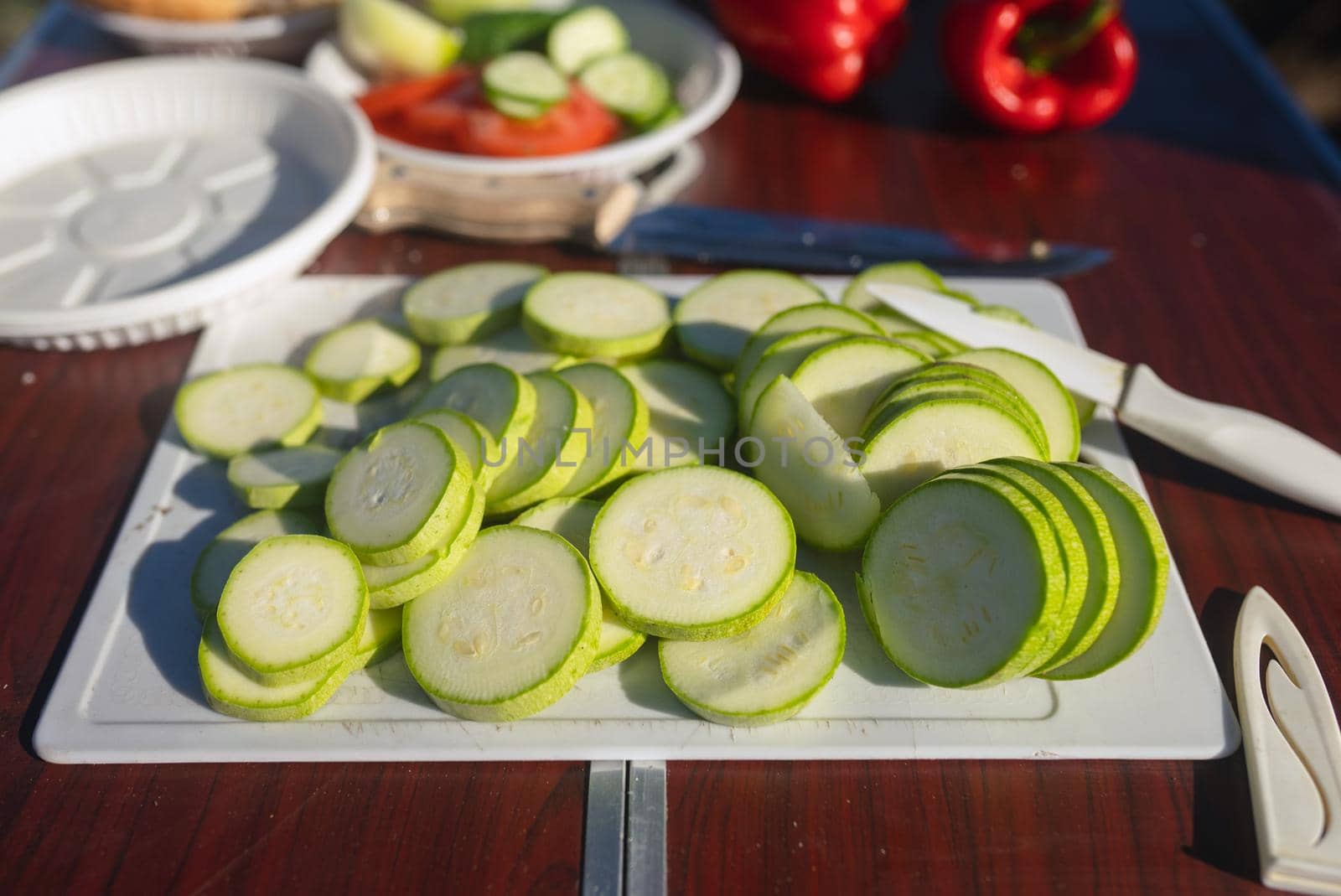 Whole and sliced fresh zucchini on wooden table. Healthy vegetarian ingredient