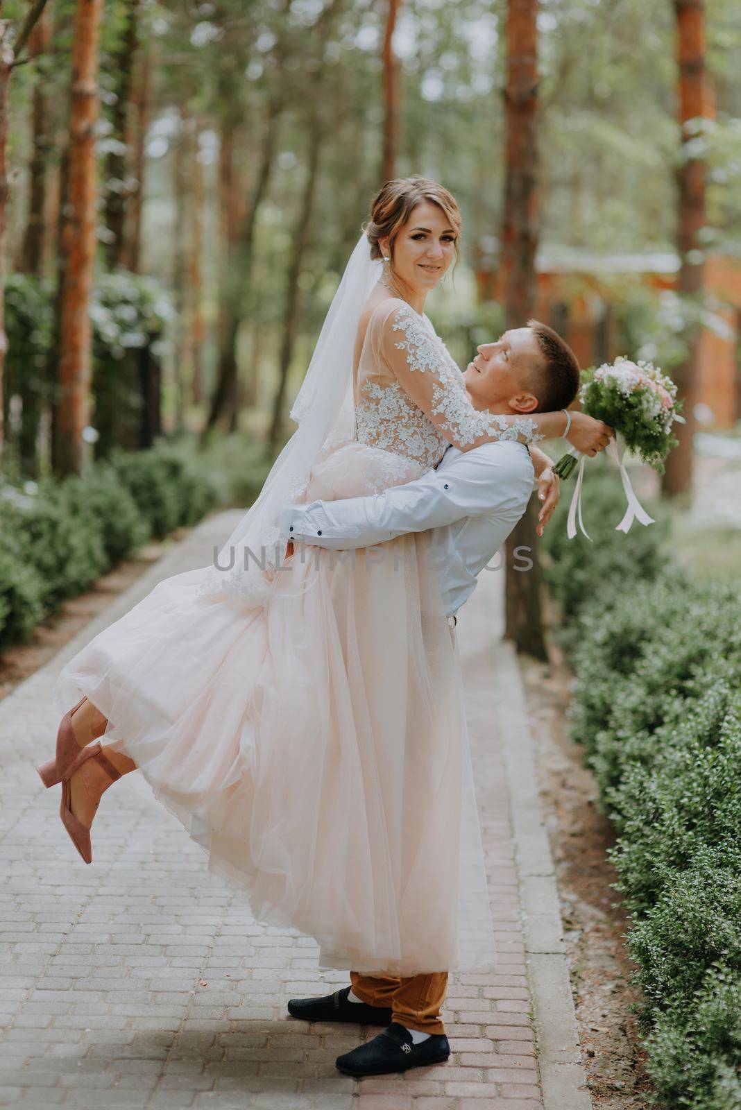Sensual portrait of a young couple. Wedding photo outdoor. Wedding shot of bride and groom in park. Just married couple embraced. by Andrii_Ko