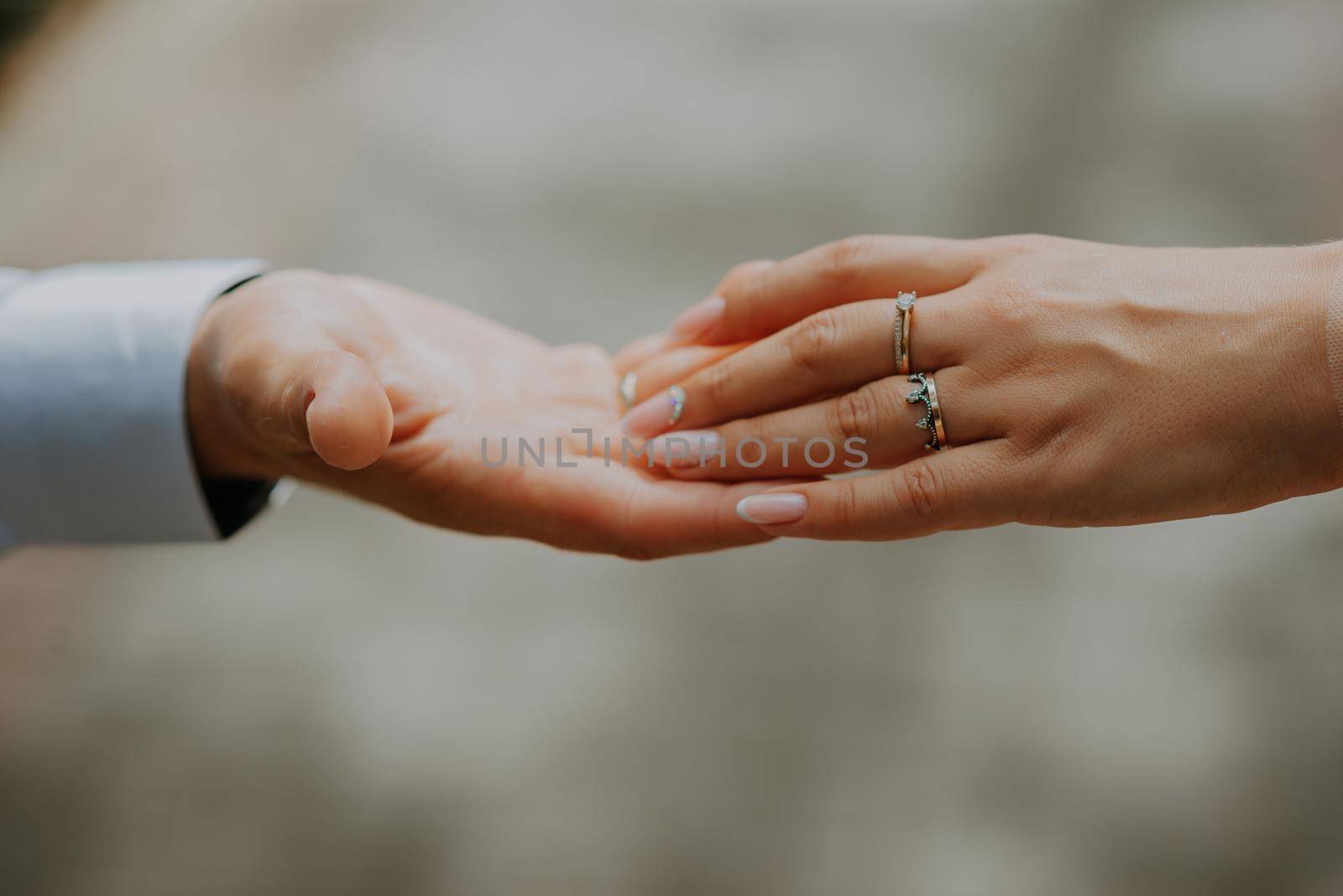 Wedding couple holding hands on sunset. Wedding rings. Man giving an engagement ring to his girlfriend. by Andrii_Ko