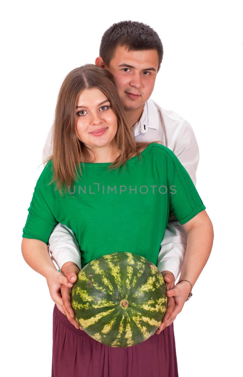 A man and a pregnant woman are holding a large watermelon in their hands. isolated on white background by aprilphoto