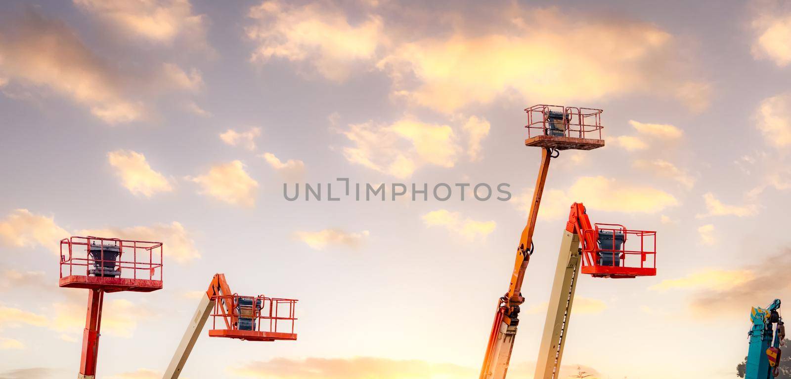 Articulated boom lift. Aerial platform lift. Telescopic boom lift against the sky. Mobile construction crane for rent and sale. Maintenance and repair hydraulic boom lift service. Crane dealership.  by Fahroni
