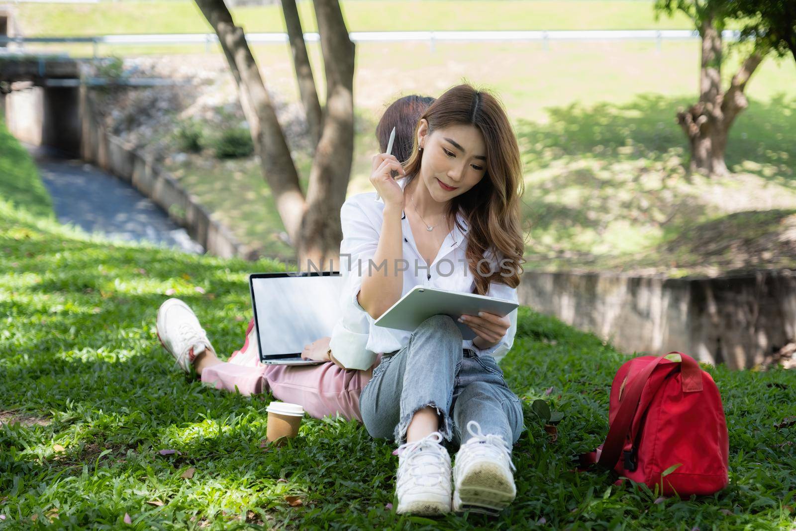 Two students are sitting in university during reading a book and communication. Study, education, university, college, graduate concept. by itchaznong