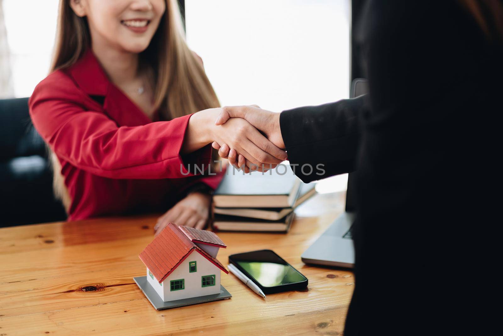 Estate agent and customer shaking hands after finished contract after about home insurance and investment loan.