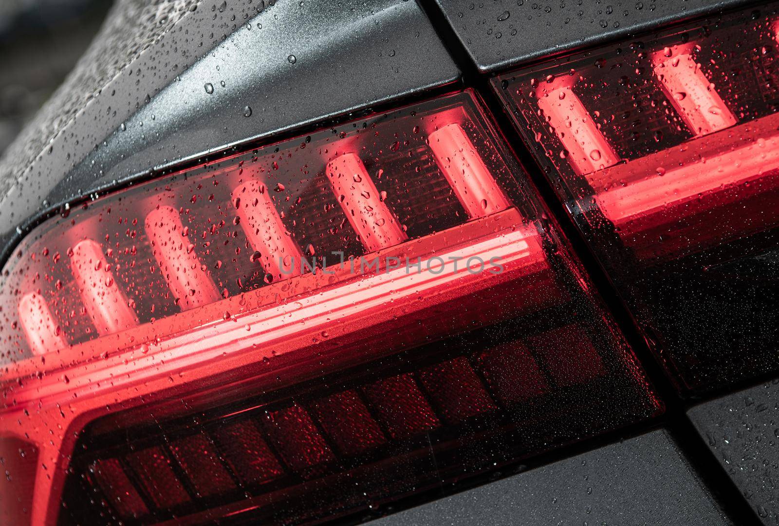 Modern Vehicle Wet From Car Washing Rear LED Light Close Up. Automotive Theme.