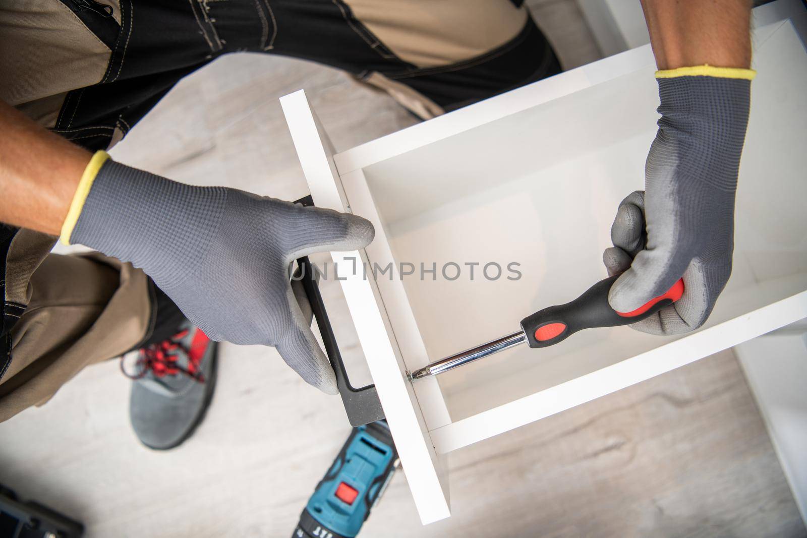 Kitchen Furniture Assembly Worker Finishing Installation Inside Residential Apartment. Drawer Close Up.