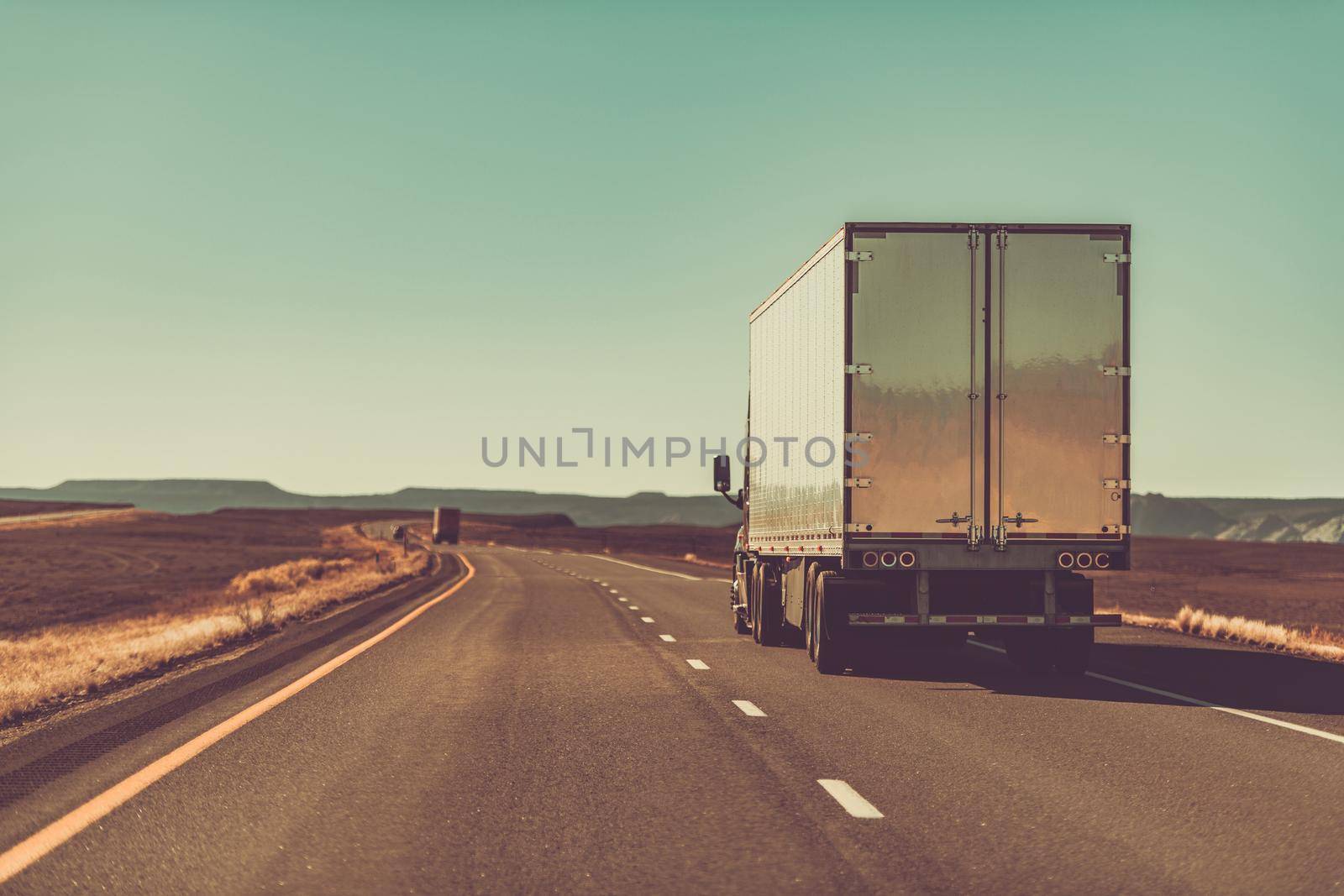 Semi Trailer Truck on an American West Route. Interstate I-70 Utah, United States of America. Rear View. 