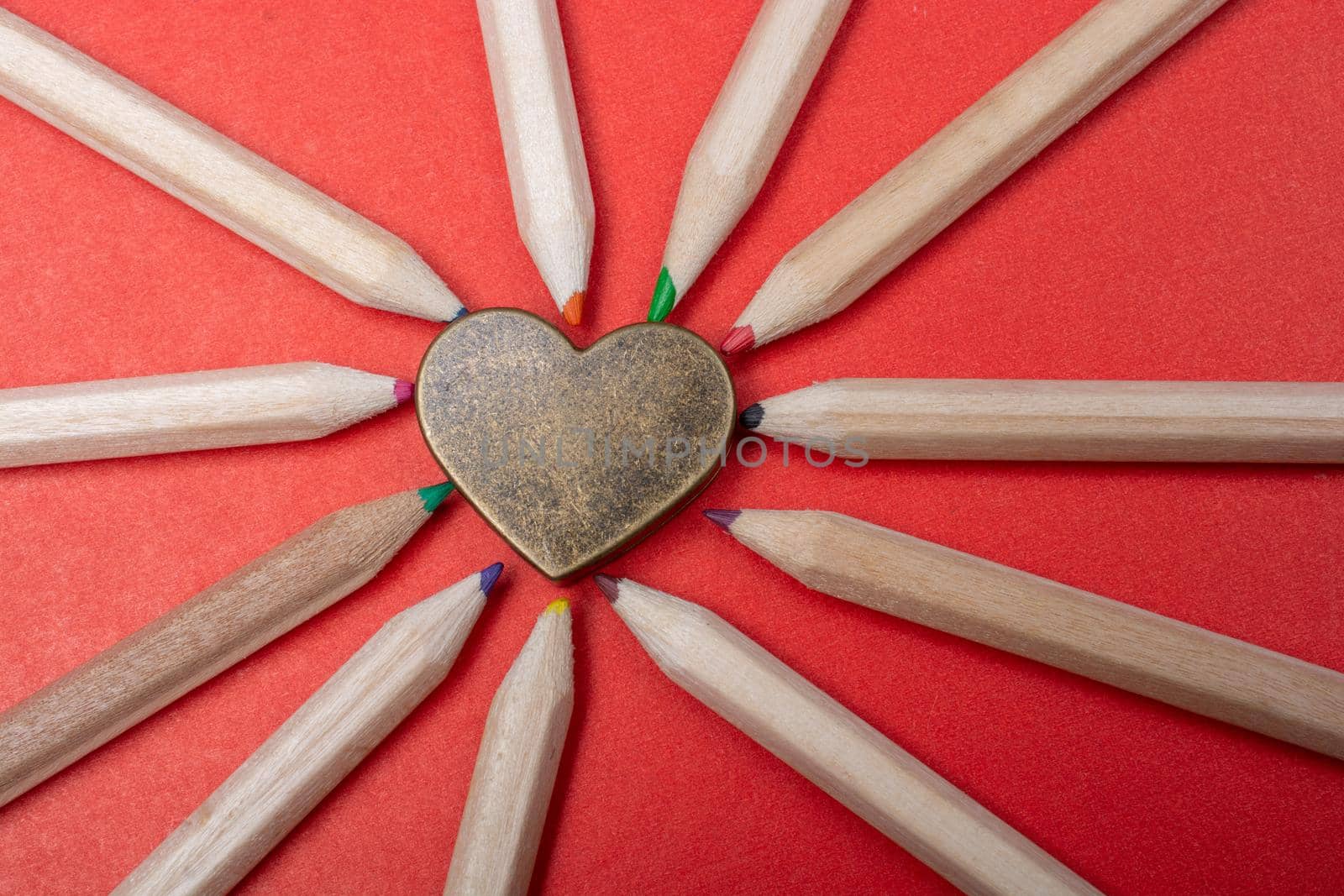 Heart laid out with sharpened multi-colored pencils