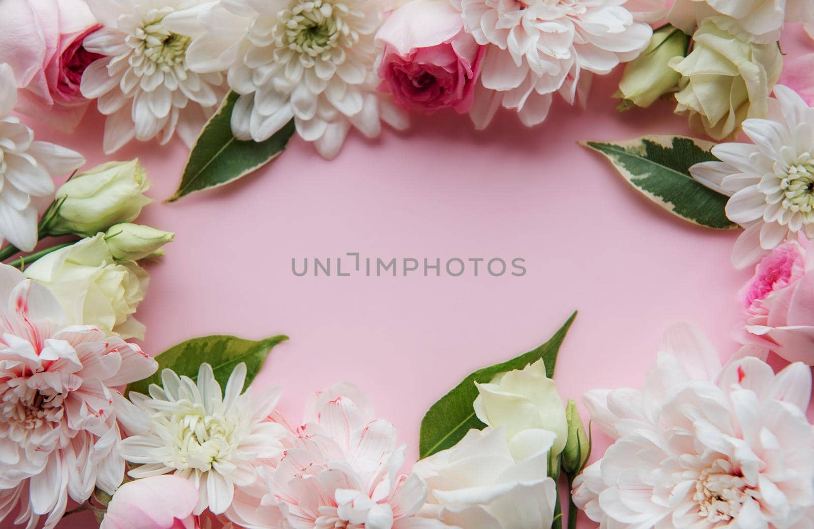 Frame made of flowers on pastel pink background. by Almaje