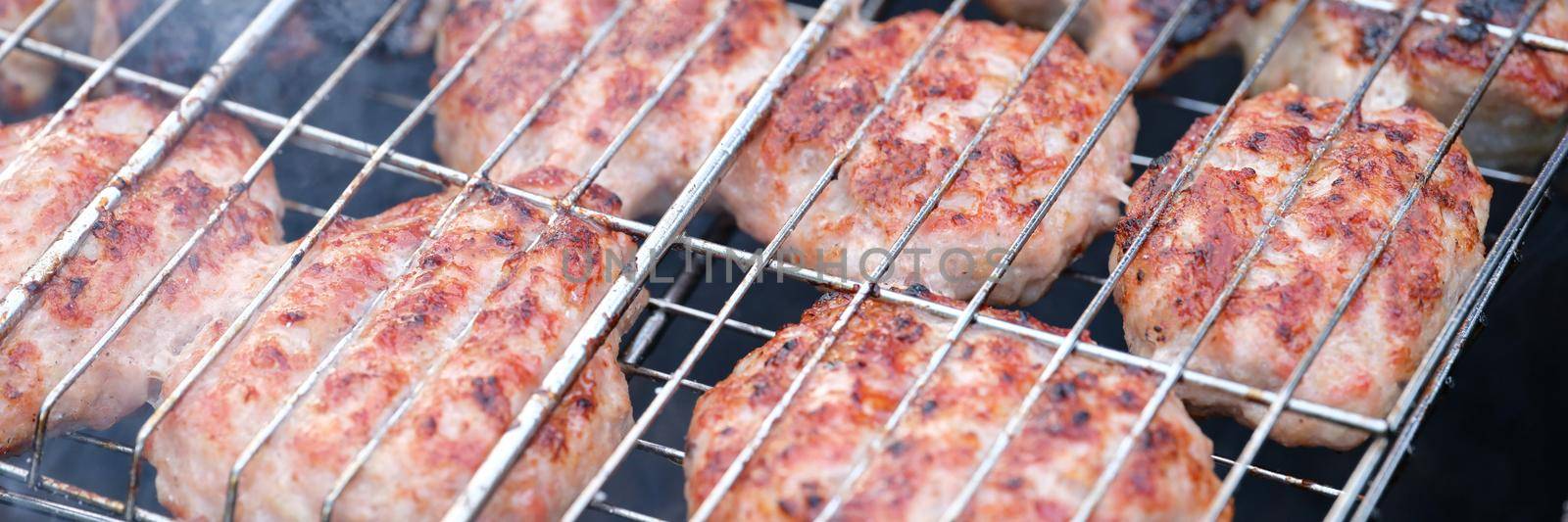 Meat cutlets are grilled on wire rack closeup by kuprevich