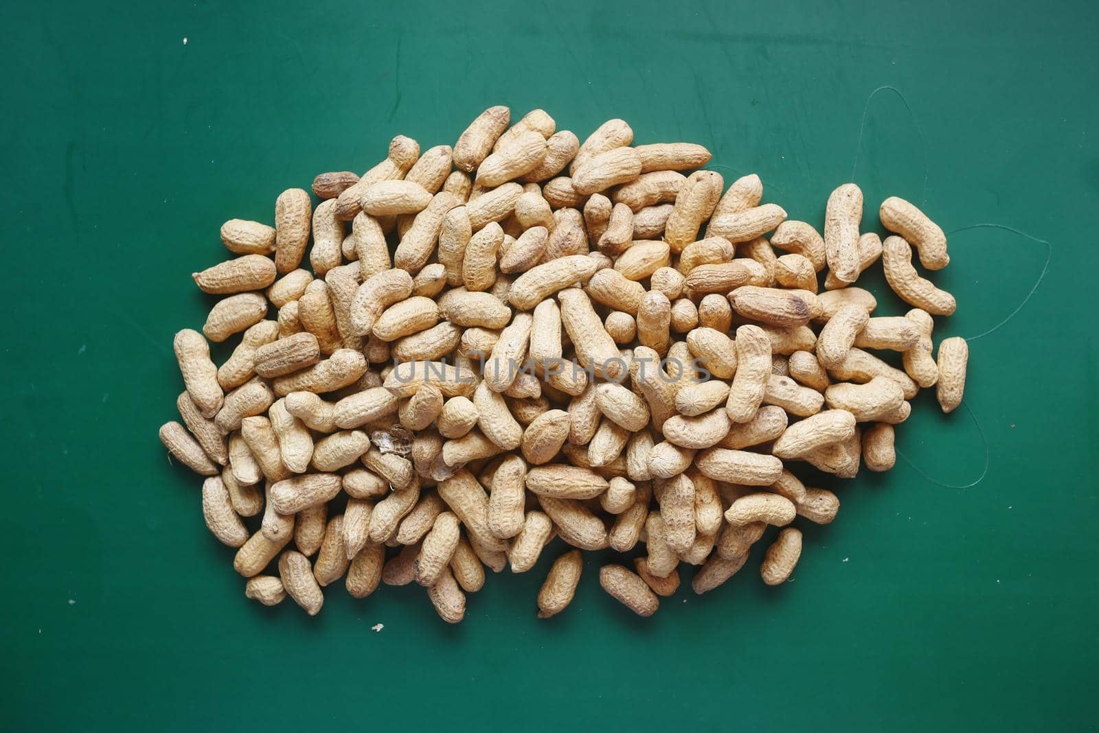 many peanuts on a green background top view ,