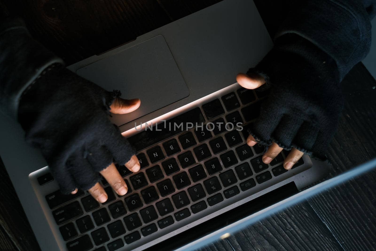 hacker hand stealing data from laptop top down.