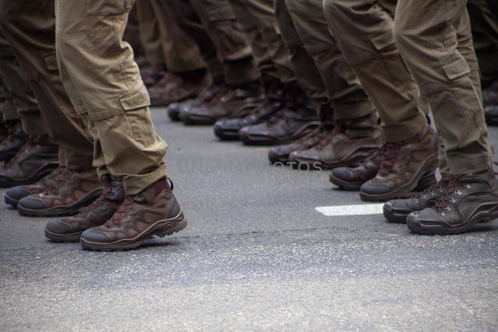 Selective focus. Motion blur. Modern military footwear on soldiers. A soldier in uniform is marching in the parade. People in the crowd. Boots on the foot.