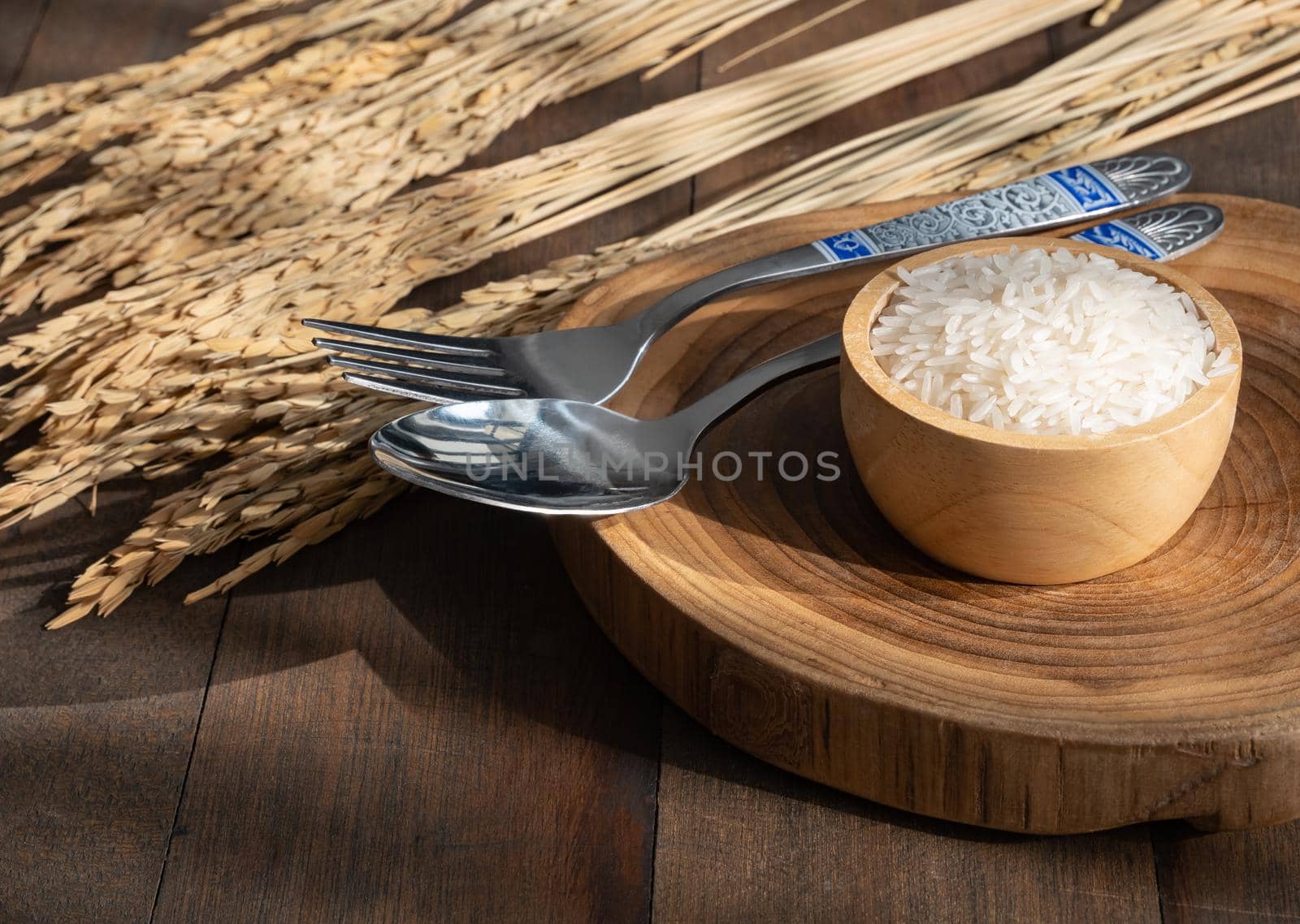Jasmine  rice in wooden bowl on spoon on grunge wood  table background  with copy space,top view