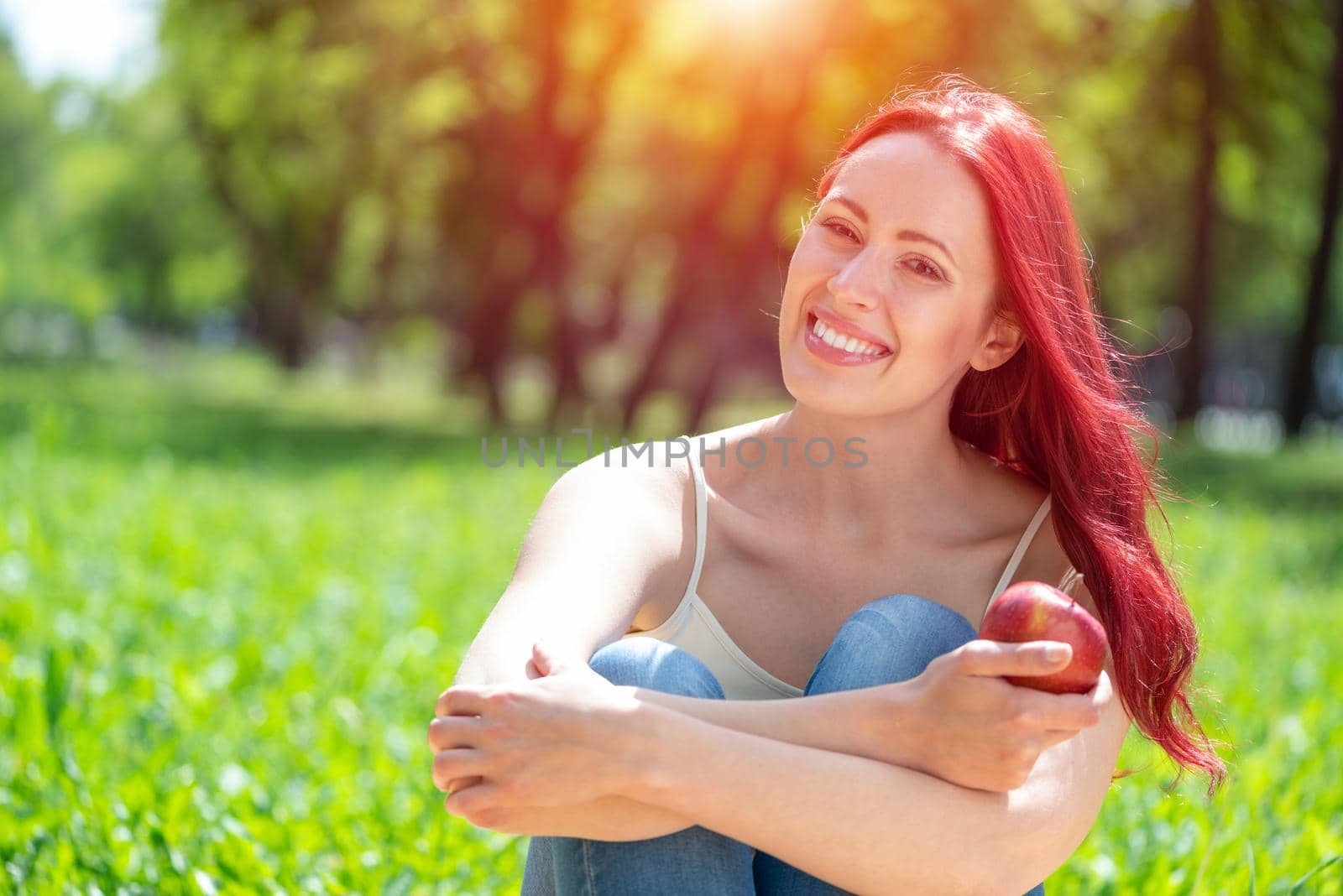 Portrait of a young attractive woman in the park. Smiling and happy