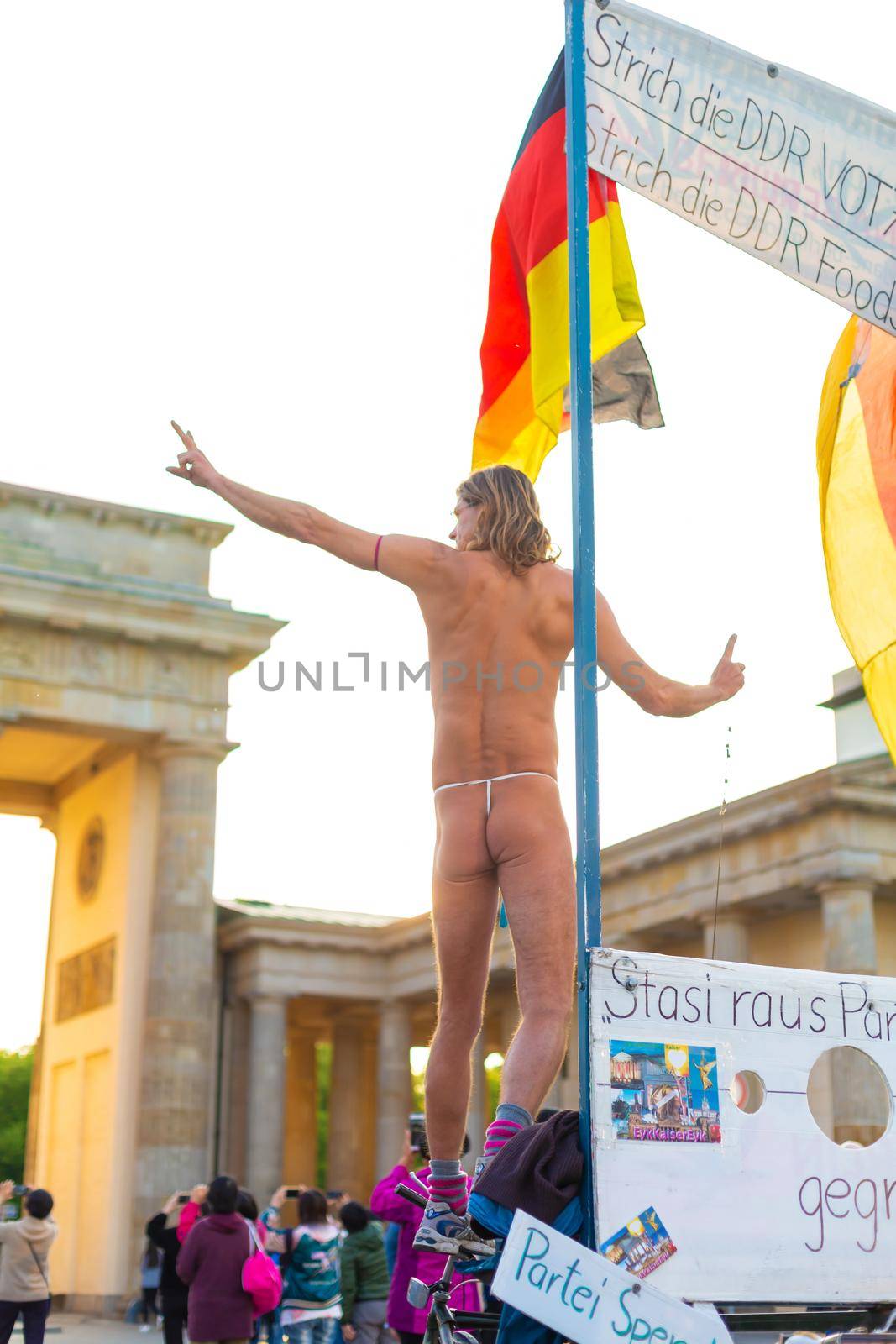 The crowd walks in the square in front of the Brandenburg Gate. Performance of a naked man. Berlin, Germany - 05.17.2019