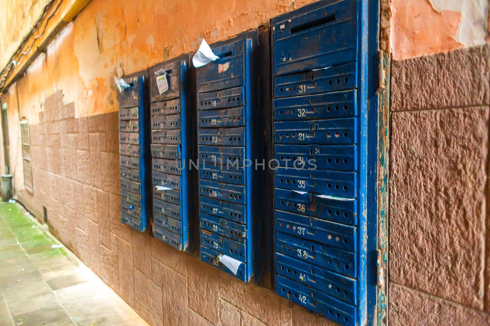 A wall with rows of mailboxes in a multi-storey residential building.